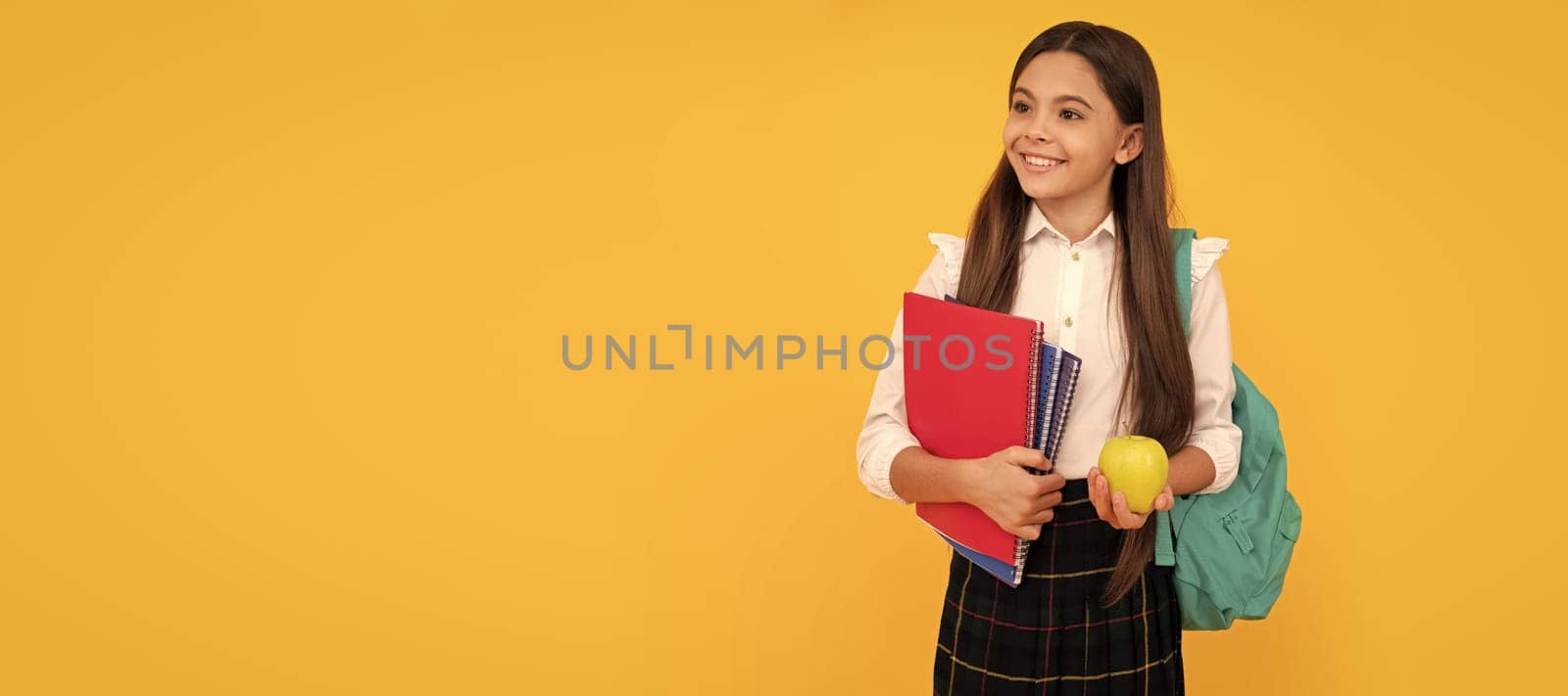 happy child with backpack and workbooks hold apple lunch in school uniform. Banner of school girl student. Schoolgirl pupil portrait with copy space. by RedFoxStudio