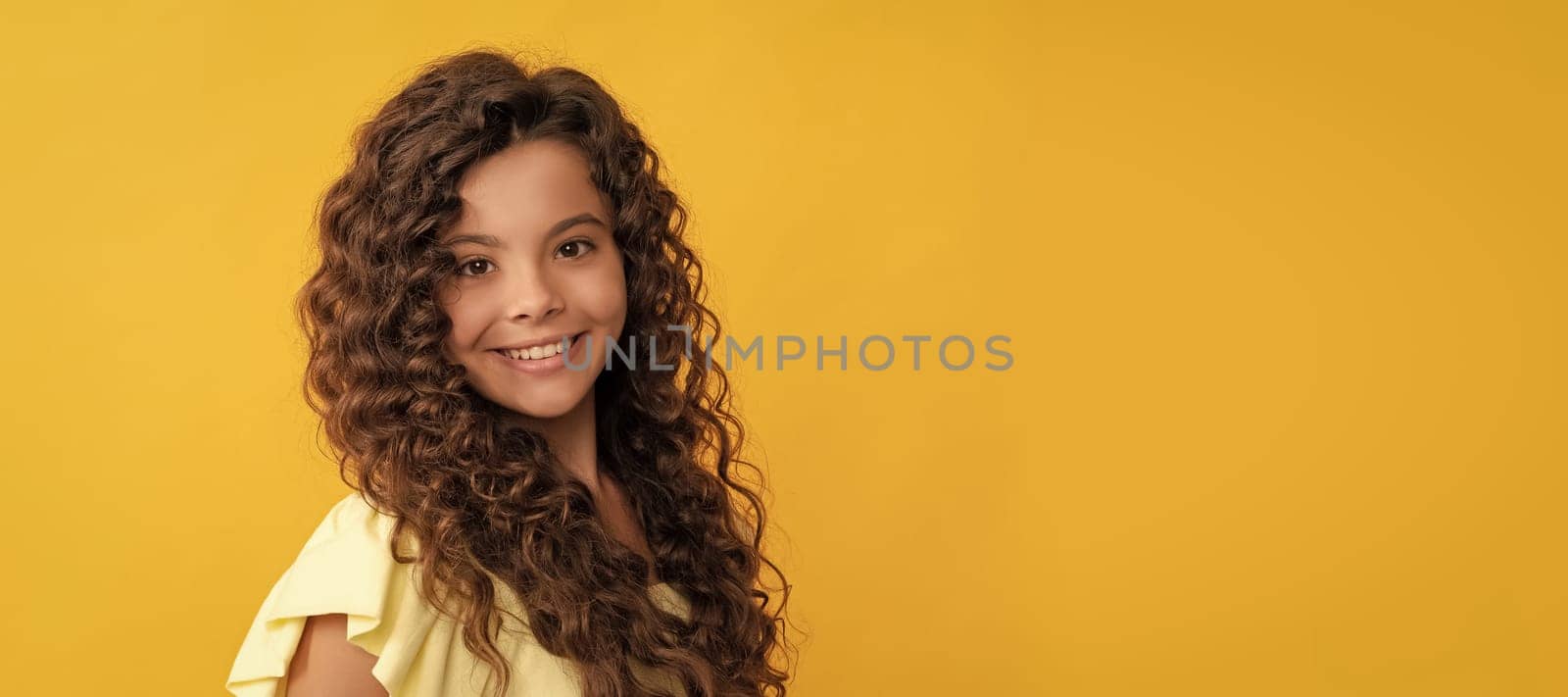 happy kid with long curly hair and perfect skin, beauty. Child face, horizontal poster, teenager girl isolated portrait, banner with copy space