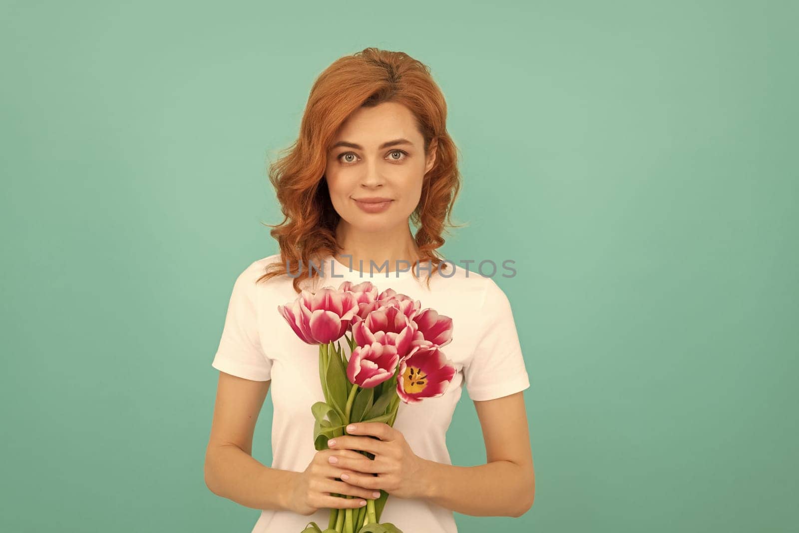girl with tulip flower bouquet on blue background.