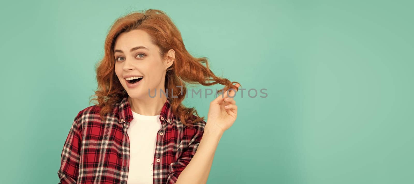 happy redhead woman with curly hair in checkered casual shirt, style. Woman isolated face portrait, banner with mock up copyspace