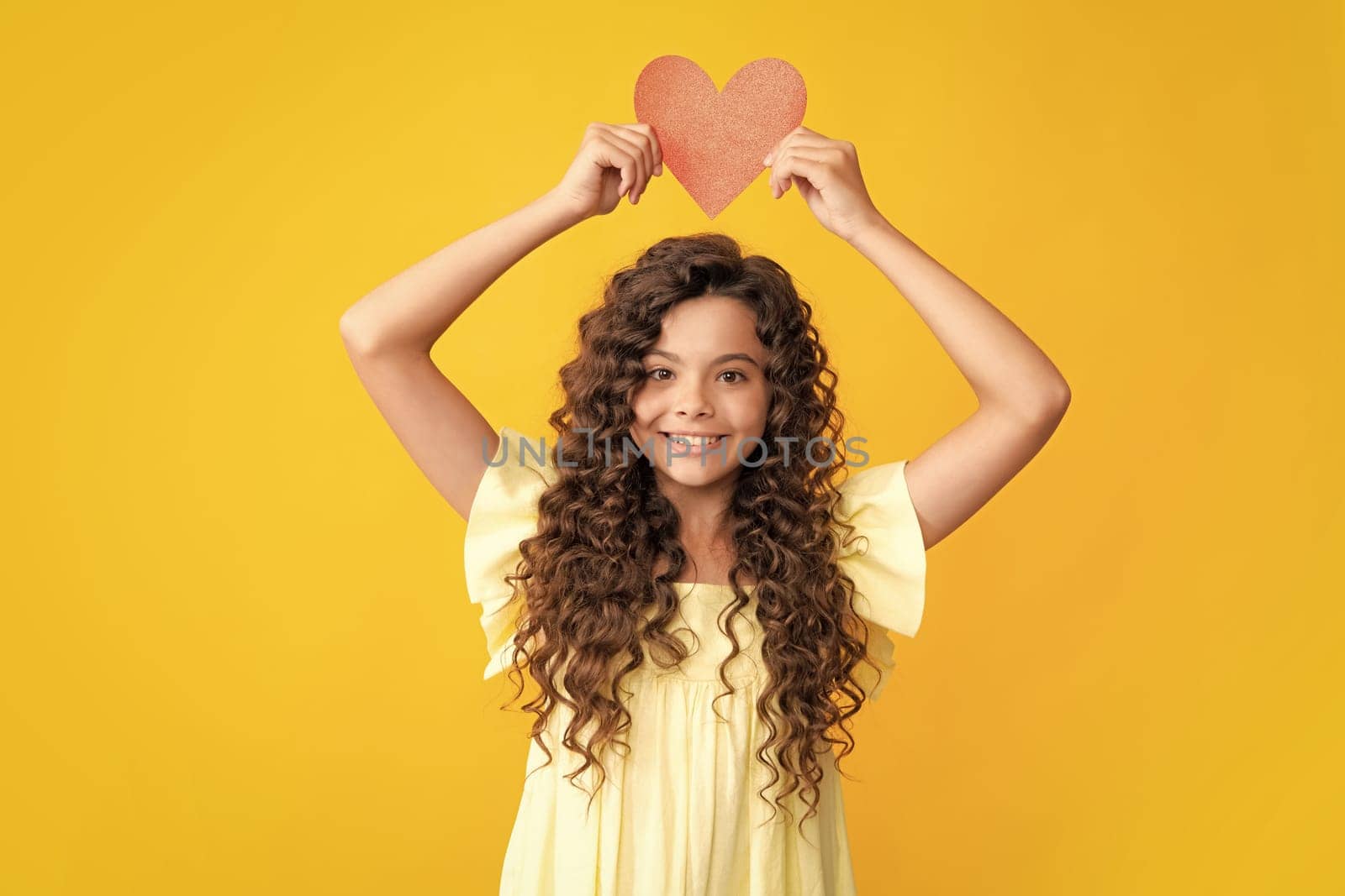 Happy teenager portrait. Lovely child teen girl with shape heart love holiday and valentine symbol. Valentine or birthday day. Gift heart present. Smiling girl