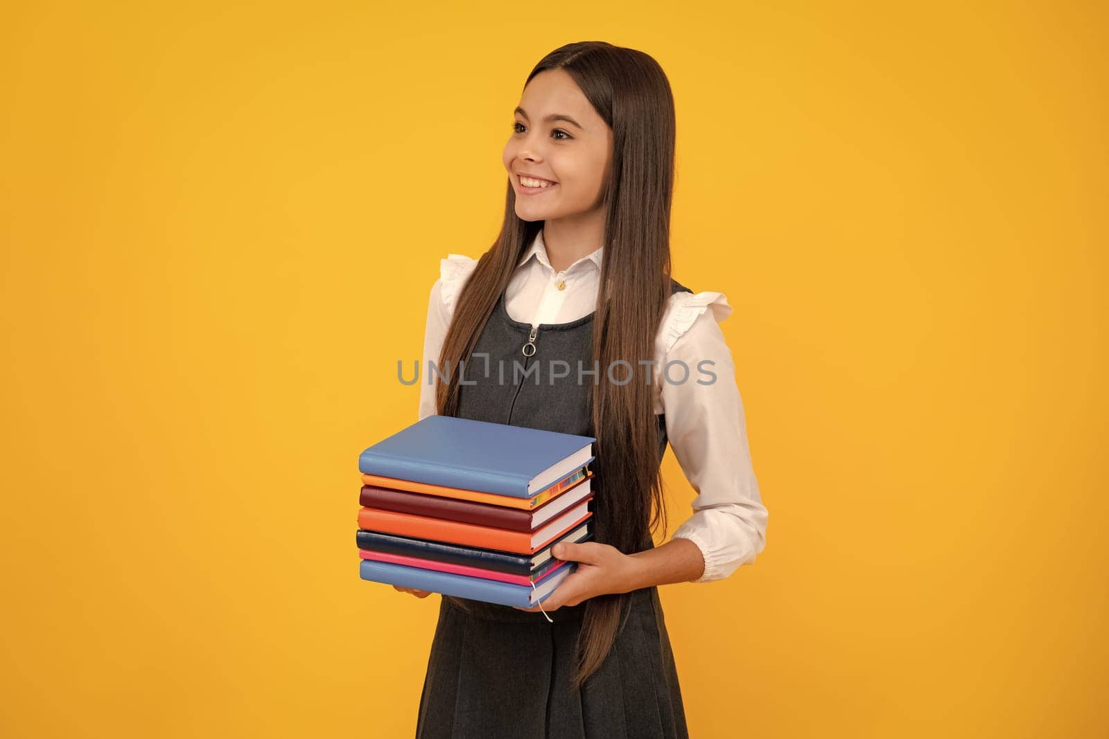 Teen girl pupil hold books, notebooks, isolated on yellow background, copy space. Back to school, teenage lifestyle, education and knowledge. by RedFoxStudio