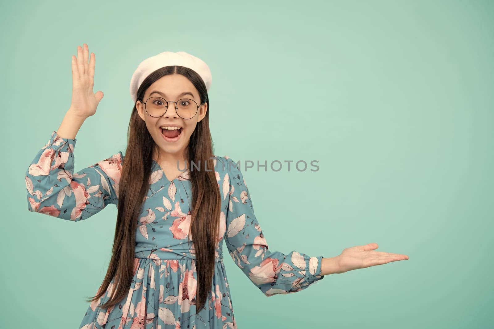 Wow, it's unbelievable. Shocked teenager child pointing aside at copy space. Teen girl pointing with two hands and fingers to the side. Excited teenager, amazed and cheerful emotions. by RedFoxStudio