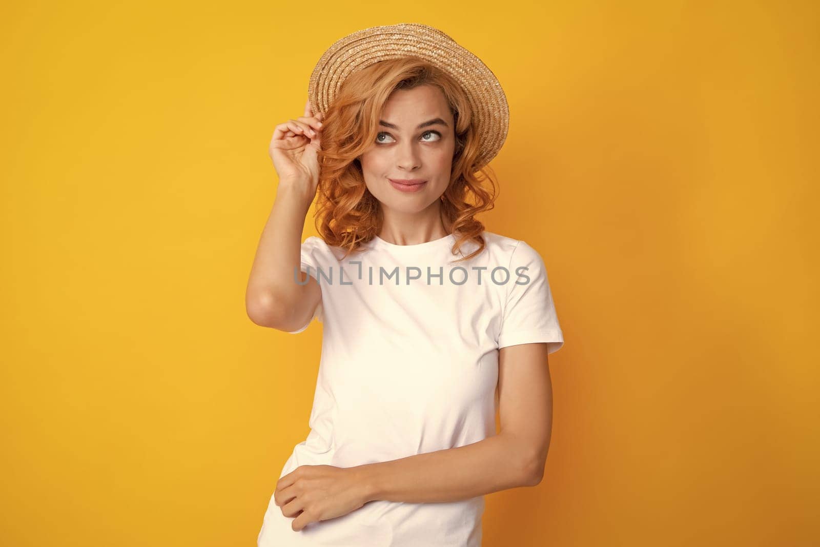 Excited amazed woman in straw hat isolated on yellow studio background