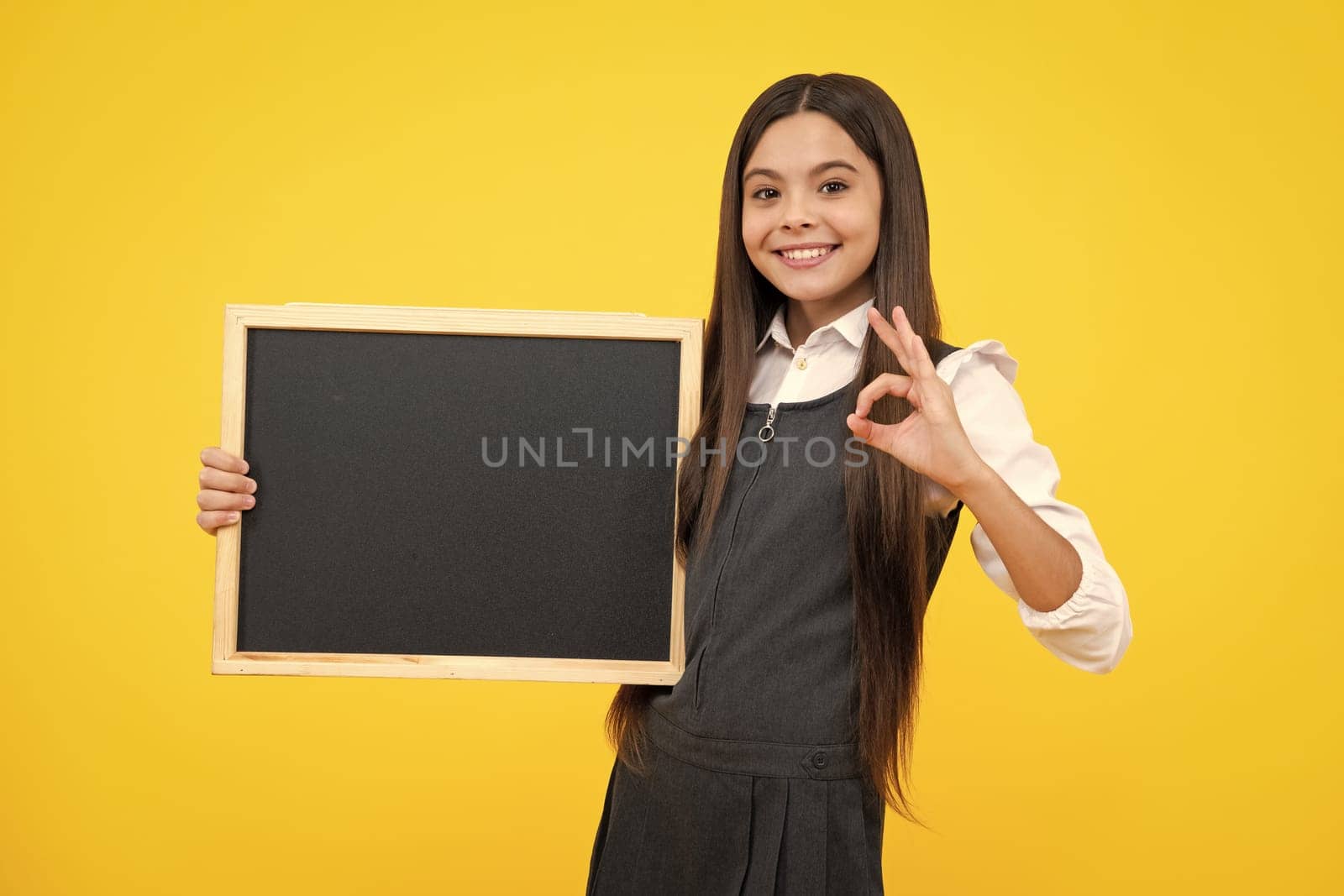 School sales board. Cheerful teenage girl kid hold blackboard chalkboard with copy space. Happy girl face, positive and smiling emotions