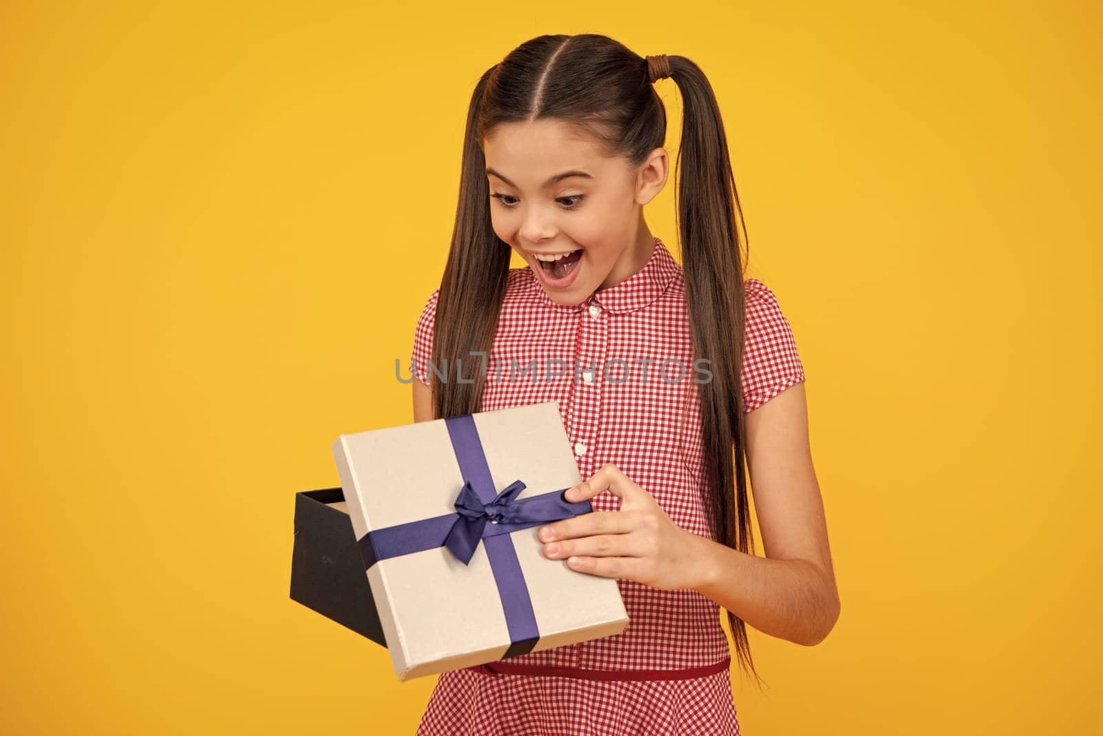 Teenager child with gift box. Present for holidays. Happy birthday, Valentines day, New Year or Christmas. Kid hold present box. Happy teenage girl, positive and smiling emotions