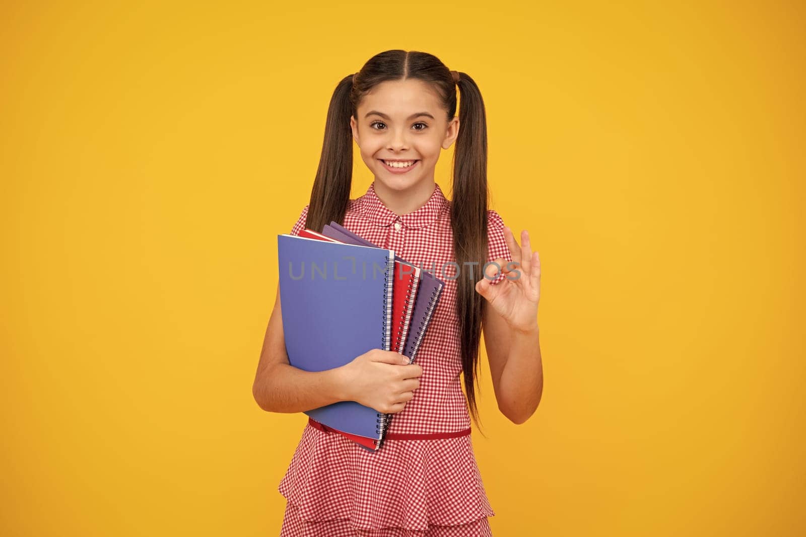 Back to school. Teenager schoolgirl with book ready to learn. School girl children on isolated yellow studio background. Happy teenager, positive and smiling emotions of teen girl. by RedFoxStudio