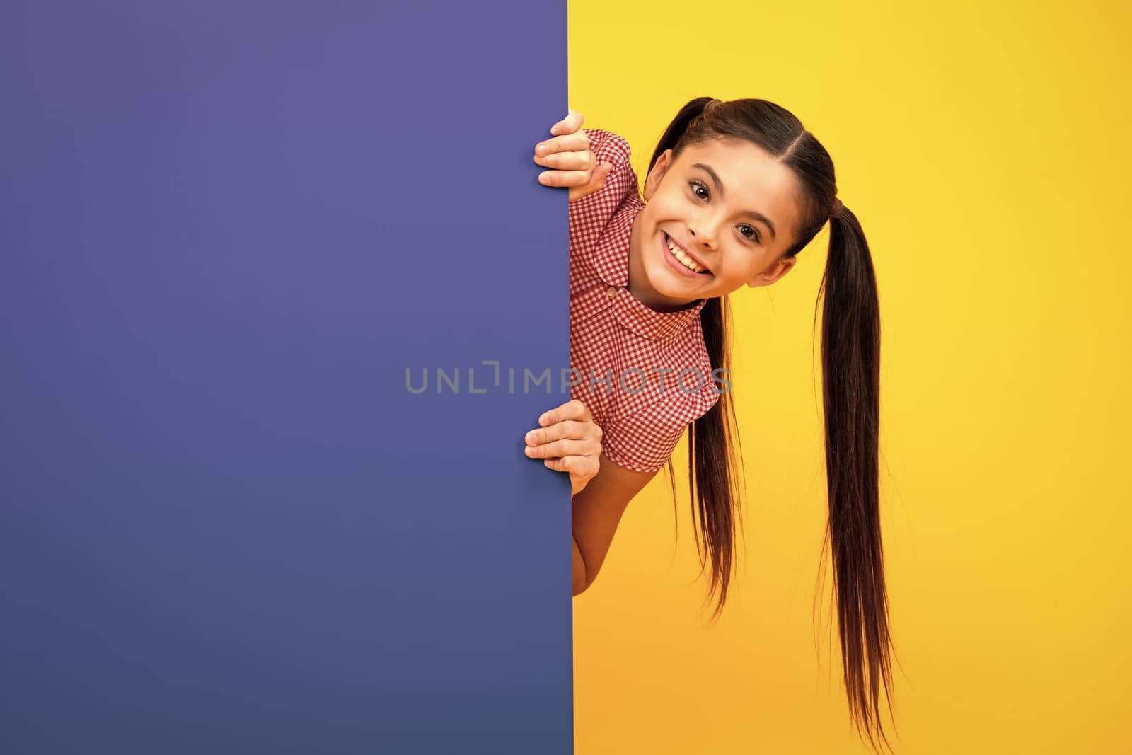 Teenage girl holds a blank for notification informing. Advertisement and sale. Markets and shops sales concept, blank board for copy space. Happy positive and smiling emotions of teen girl