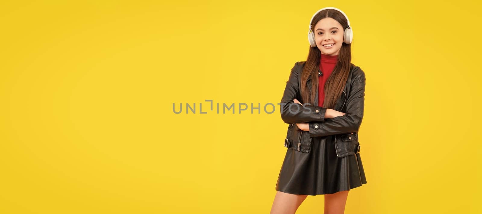 back to school. cheerful teen girl in headphones full length. music lover. Child portrait with headphones, horizontal poster. Girl listening to music, banner with copy space