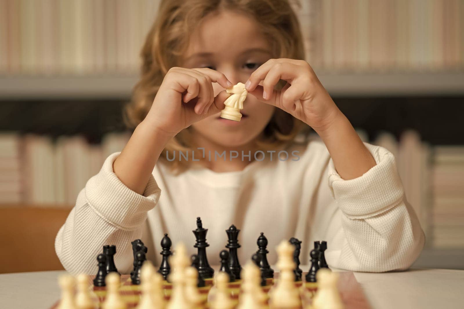 Little kid chessman play chess game, checkmate. Child playing chess in the room. by RedFoxStudio