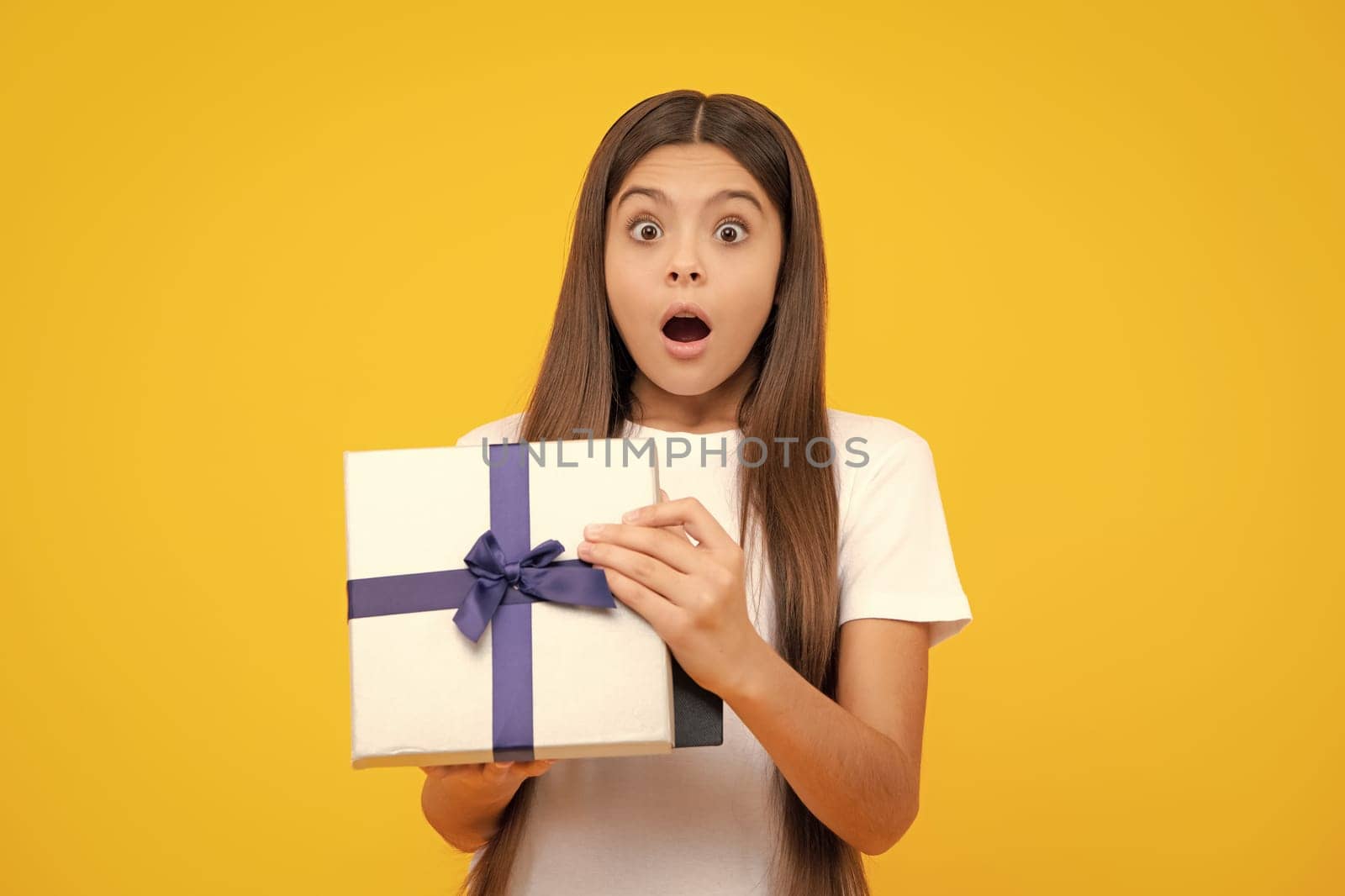 Amazed surprised emotions of young teenager girl. Teenager kid with present box. Teen girl giving birthday gift. Present, greeting and gifting concept. by RedFoxStudio