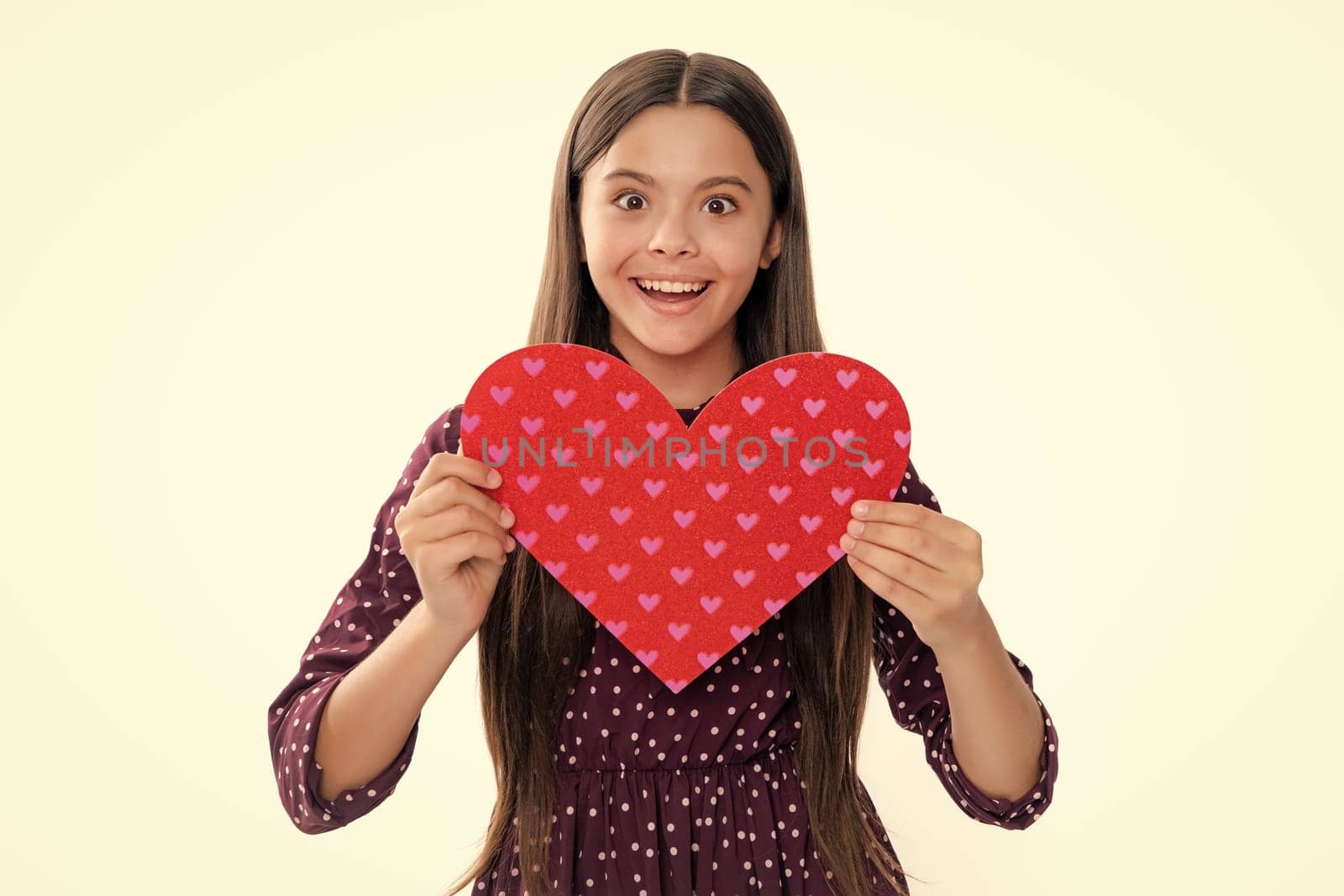 Lovely romantic teenage girl hold red heart symbol of love for valentines day isolated on white background. Portrait of happy smiling teenage child girl