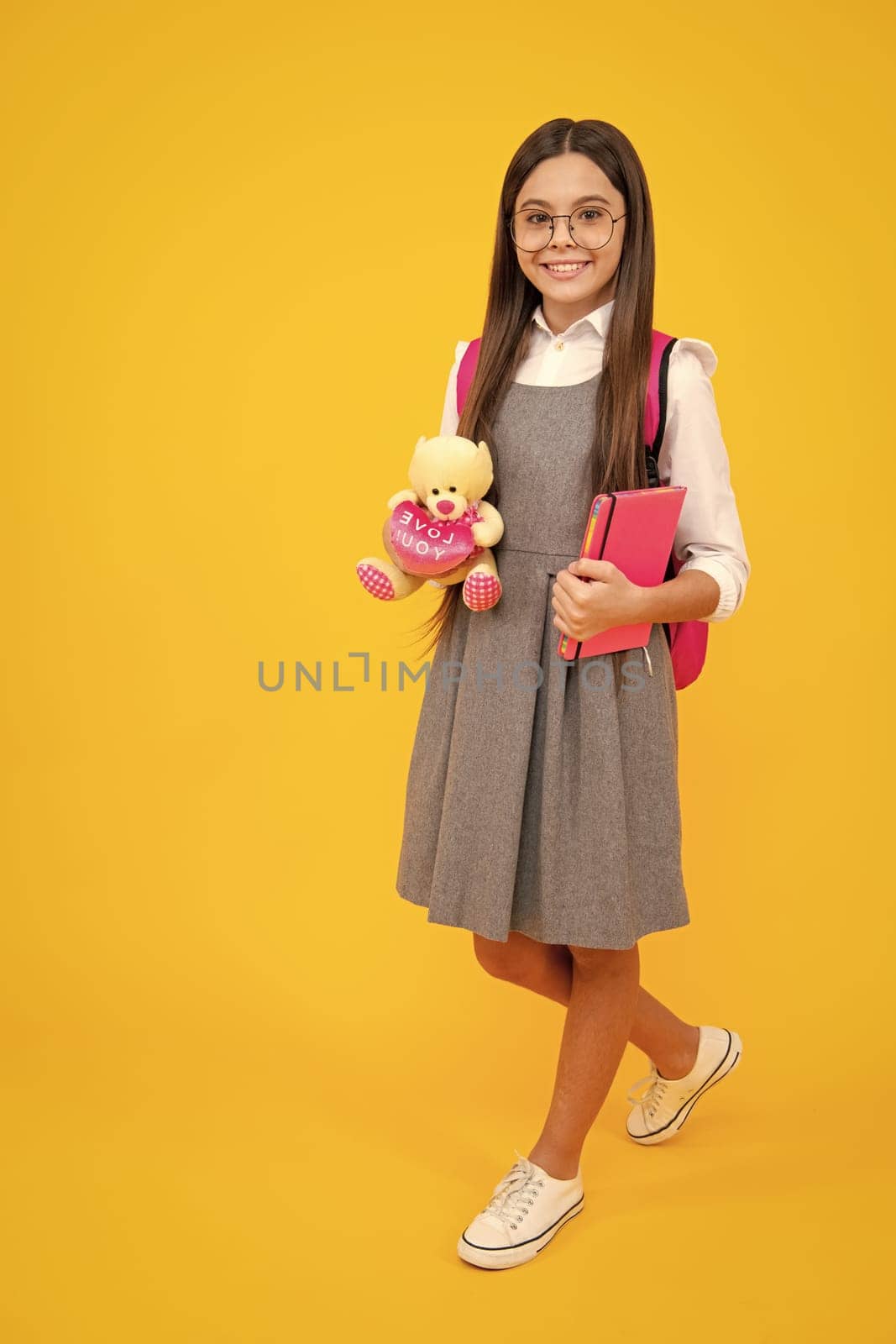School girl hold toy. School children with favorite toys on yellow isolated background. Childhood concept. by RedFoxStudio