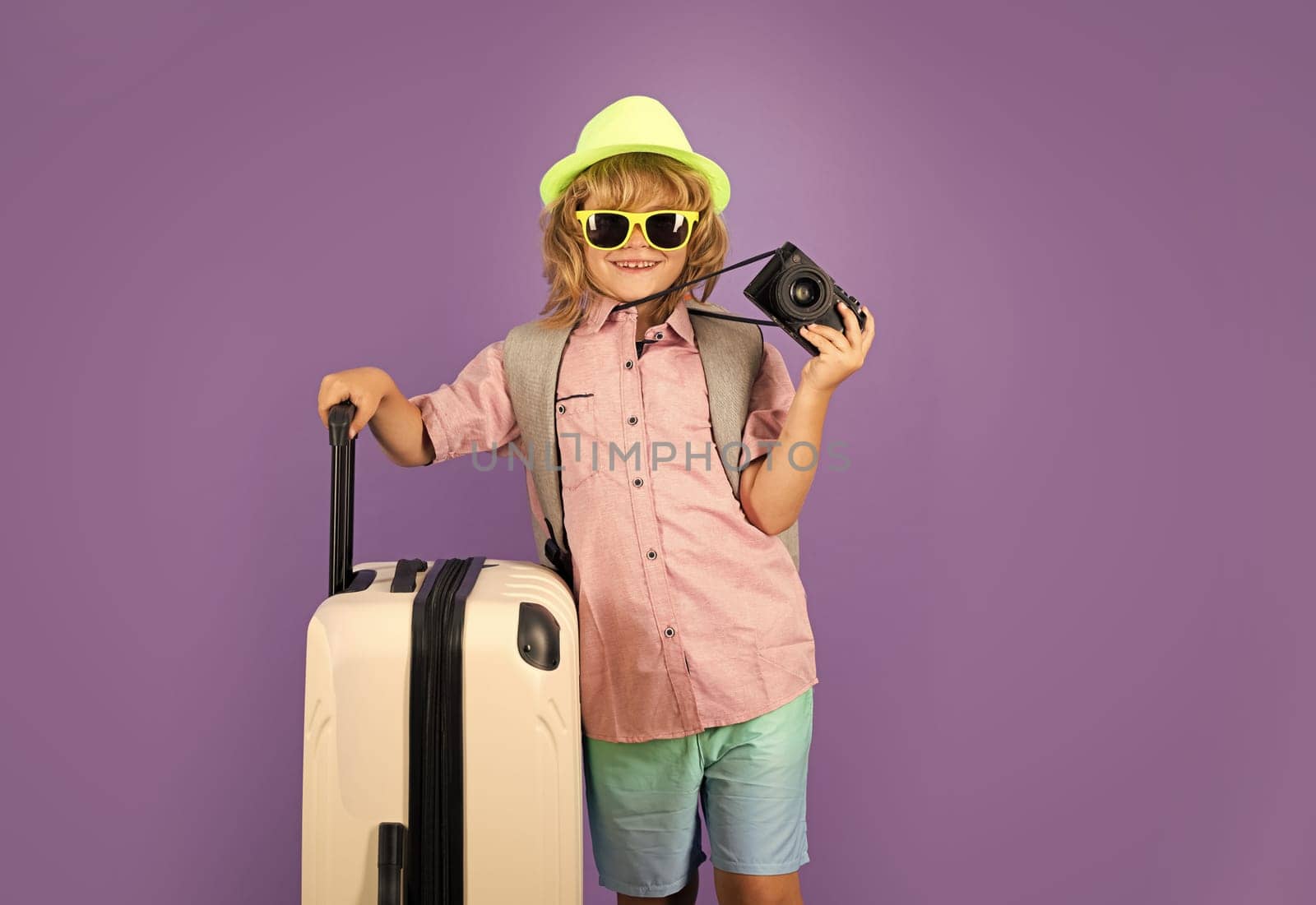Child travel with travel bag. Child with suitcase dreams of travel, adventure, vacation. Studio kids portrait