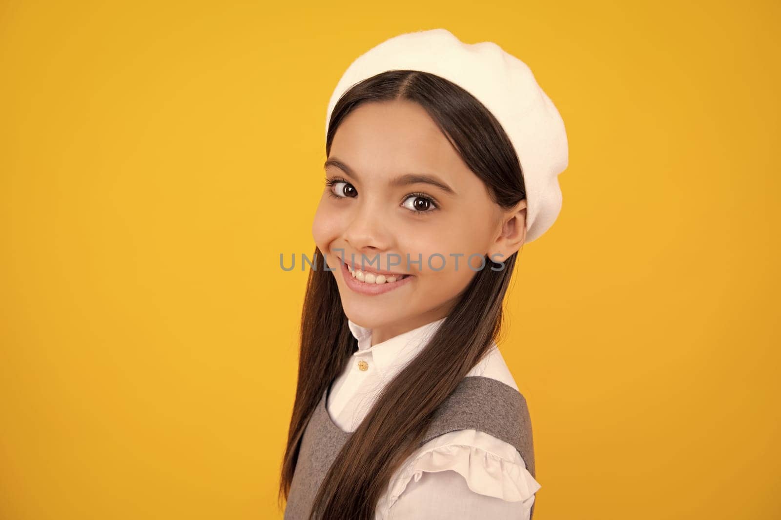 Portrait of cute positive little girl isolated on yellow background. Attractive caucasian child smiling and looking at camera. Happy face, positive and smiling emotions of teenager girl. by RedFoxStudio