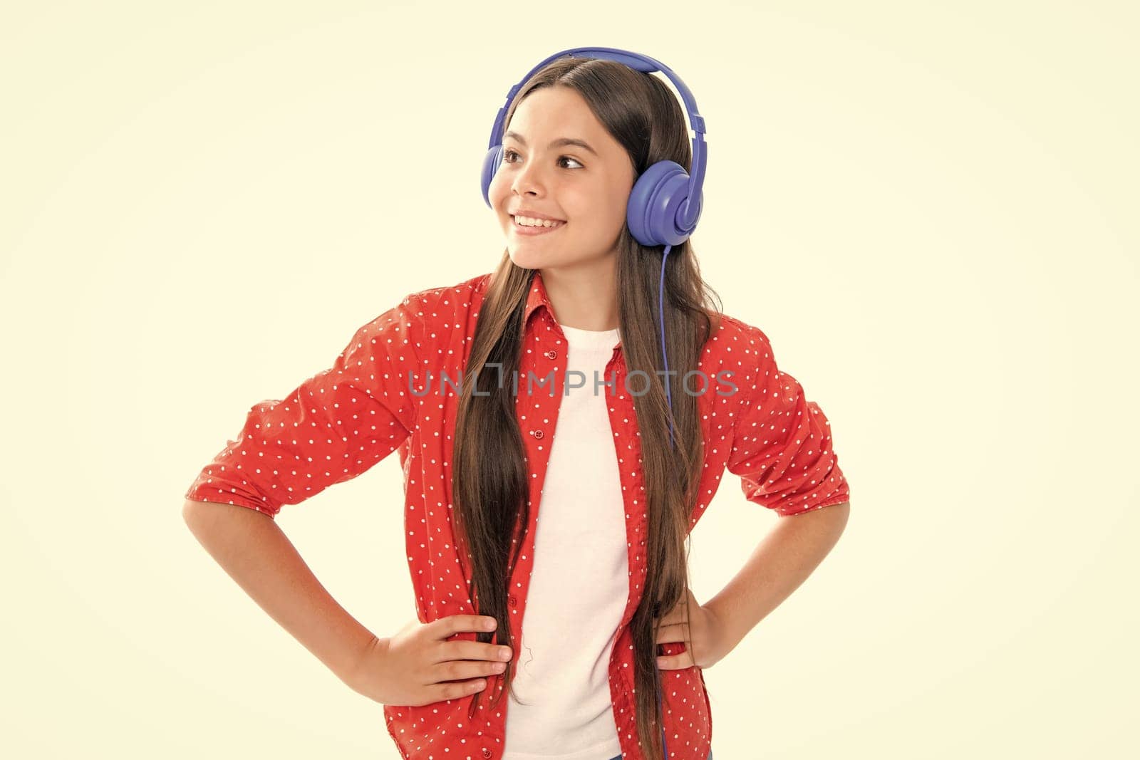 Funny kid girl 12, 13, 14 years old listen music with headphones. Teenage girl with headphones listening songs on headset earphone. Portrait of happy smiling teenage child girl