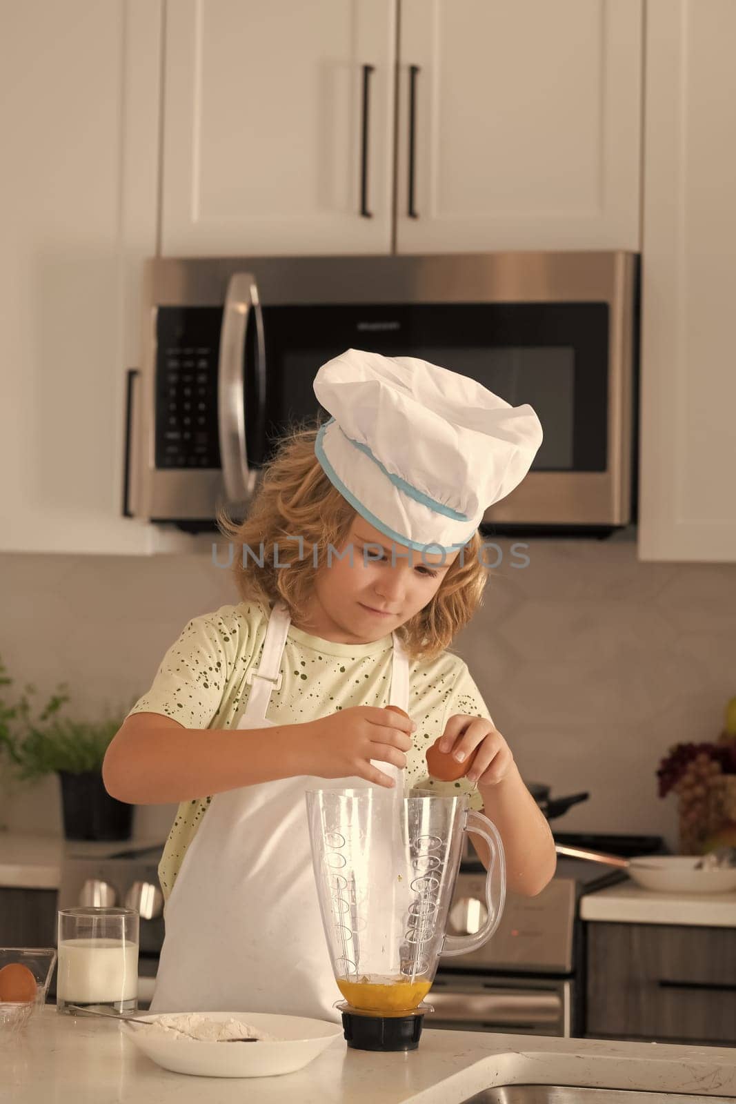 Chef kid cook baking at home kitchen. Kid chef cook cookery at kitchen. Cooking, culinary and kids. Little boy in chefs hat and apron. by RedFoxStudio