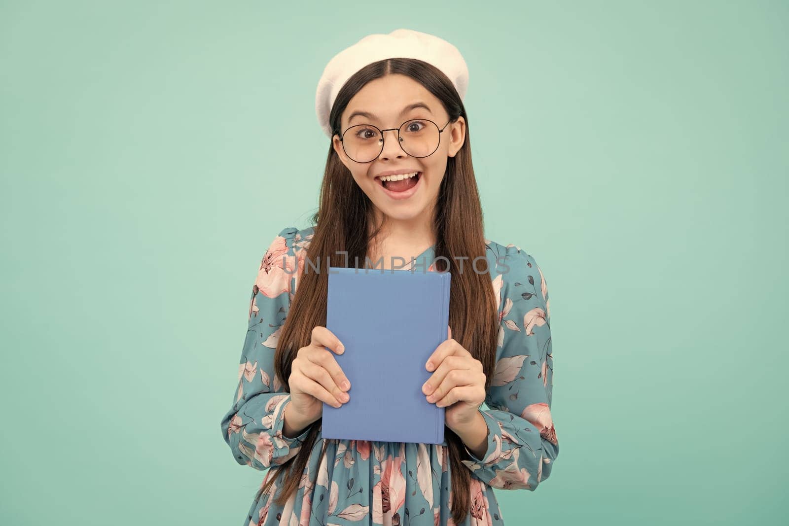 Teen girl pupil hold books, notebooks, isolated on blue background, copy space. Back to school, teenage lifestyle, education and knowledge. Excited teenager, amazed and cheerful emotions. by RedFoxStudio