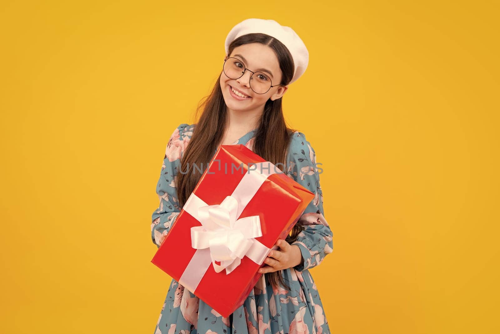 Emotional teenager child hold gift on birthday. Funny kid girl holding gift boxes celebrating happy New Year or Christmas. Happy teenager, positive and smiling emotions. by RedFoxStudio