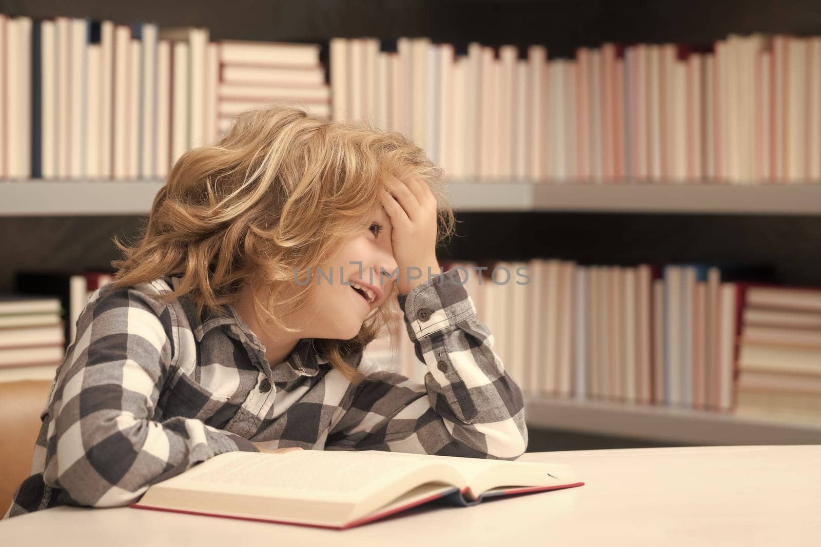 Childhood and education concept. Child reading book in a book store or library