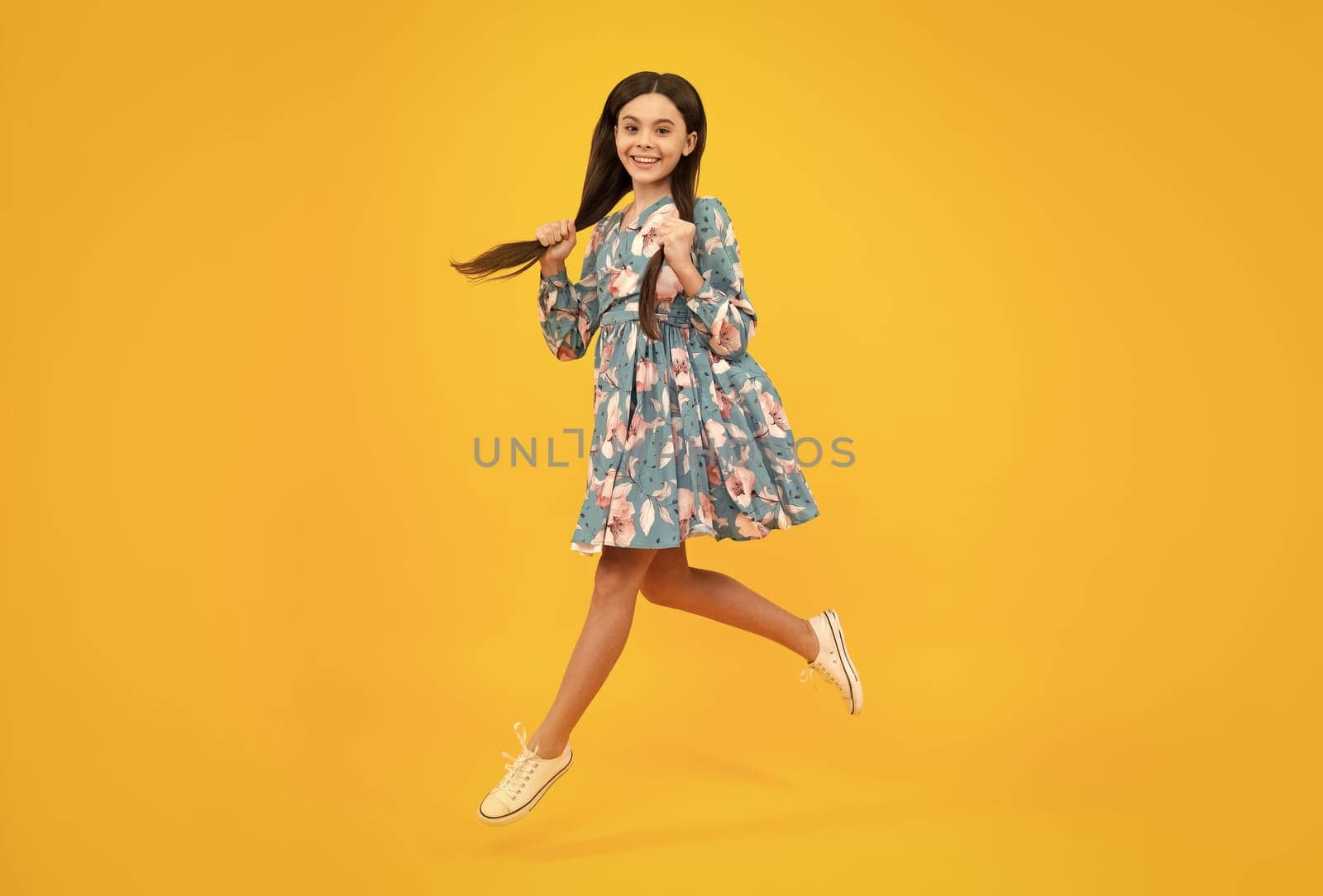 Full length little overjoyed teen girl 12, 13, 14 year old jump and fly isolated on yellow background studio. by RedFoxStudio