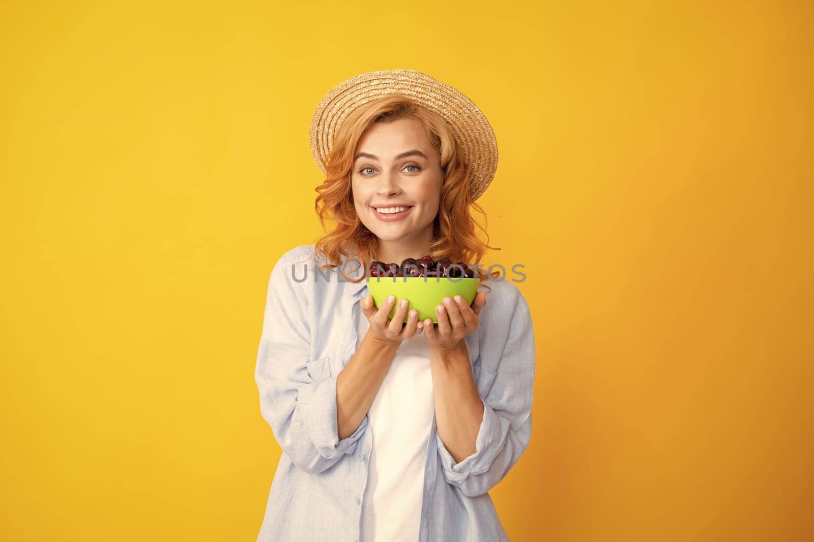 Portrait of woman with cherries on yellow studio isolated background. by RedFoxStudio