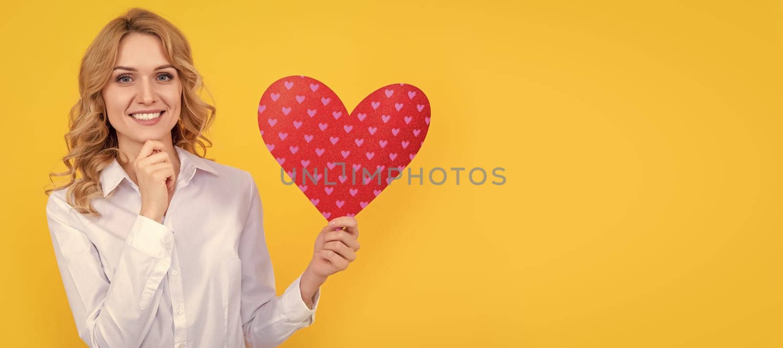 happy woman with red love heart on yellow background. february 14. Woman isolated face portrait, banner with mock up copy space