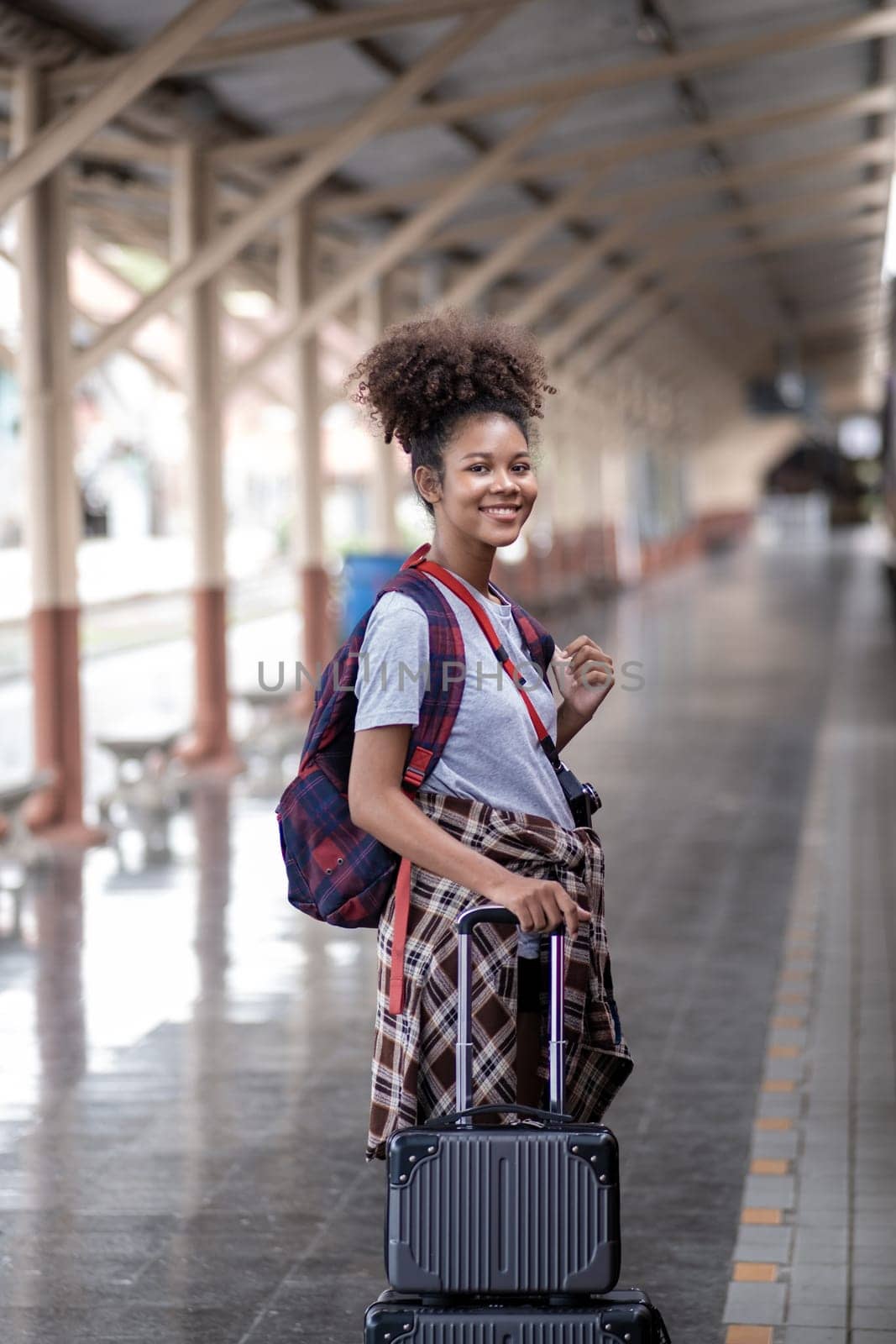 Young female traveler walking standing with a suitcase at train station. woman traveler tourist walking standing smiling by wuttichaicci