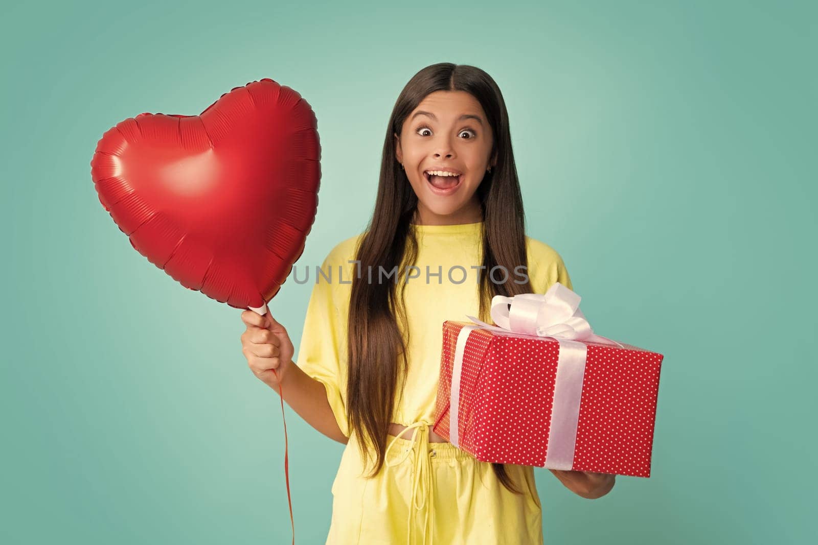 Cute teenager child girl congratulate with valentines day, giving romantic gift box.Love valentines, heart balloon. Birthday holiday concept. Excited face of teenager girl