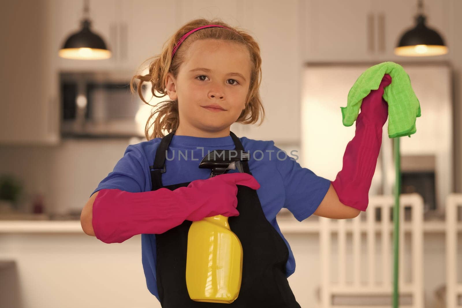 Cleaning house. Child use duster and gloves for cleaning. Funny child mopping house
