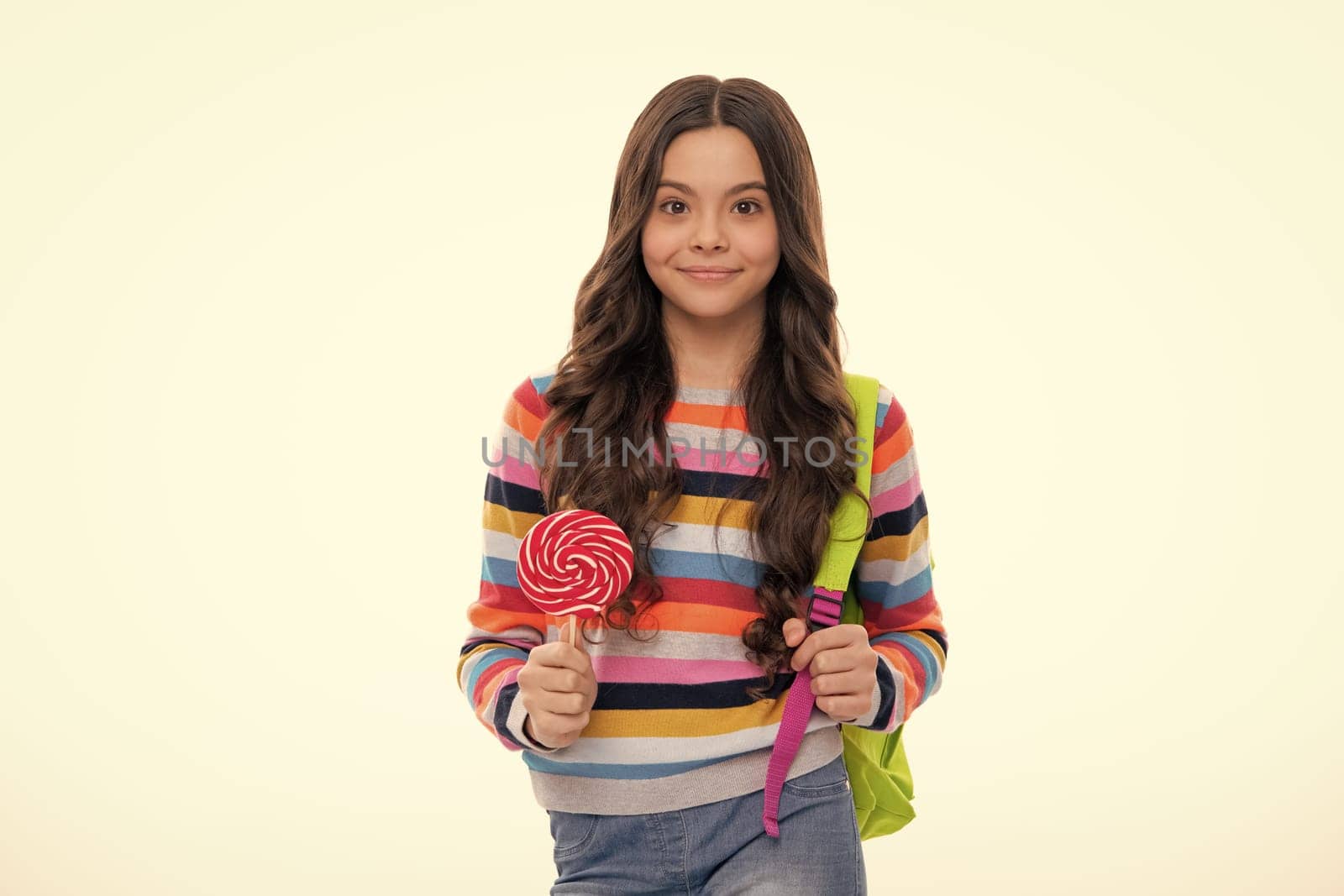 Cool teen child with lollipop over white isolated background. Sweet childhood life. Teen girl with yummy lollipop candy. Happy girl face, positive and smiling emotions