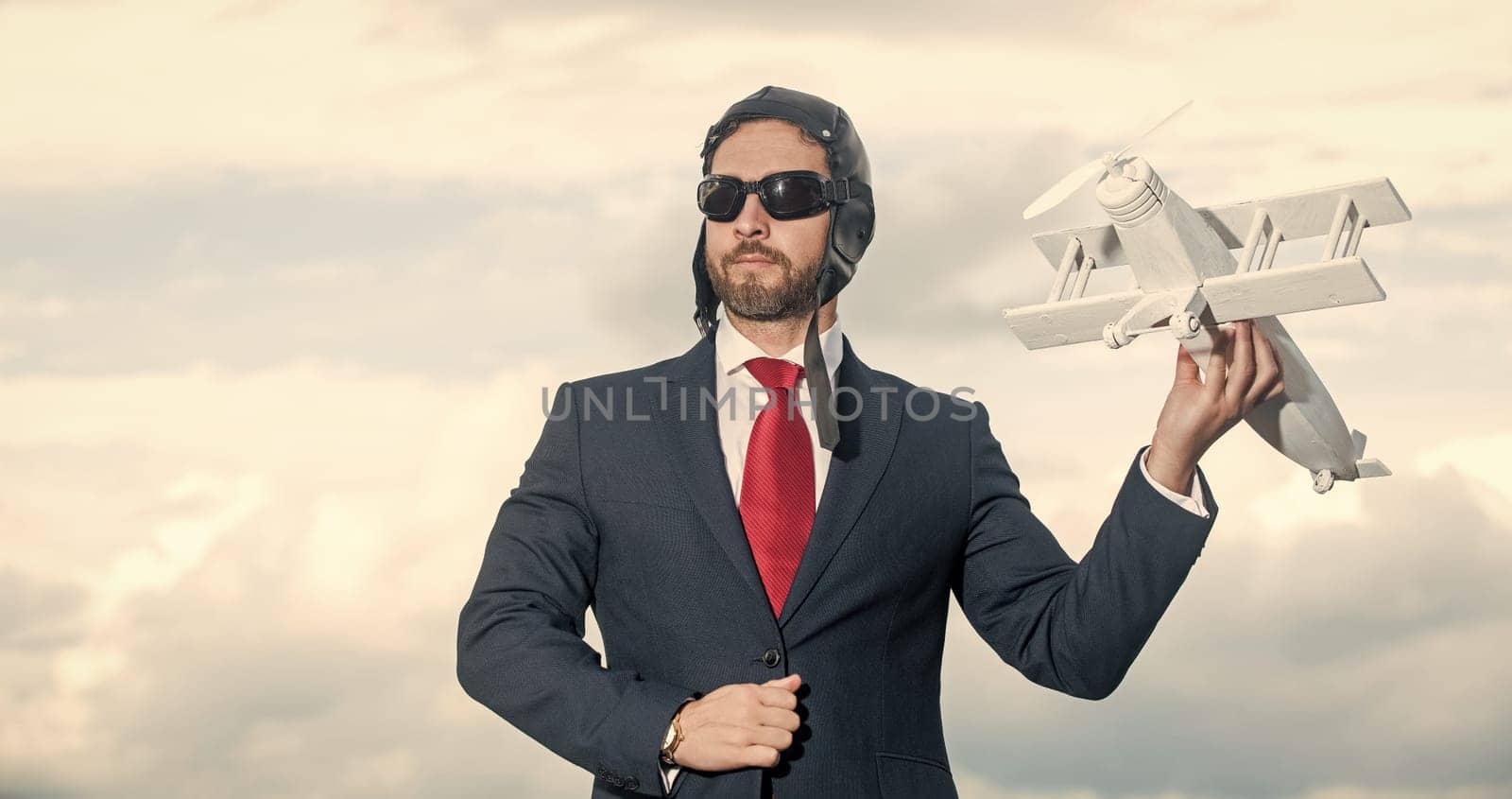 businessman in suit and pilot hat launch plane toy.