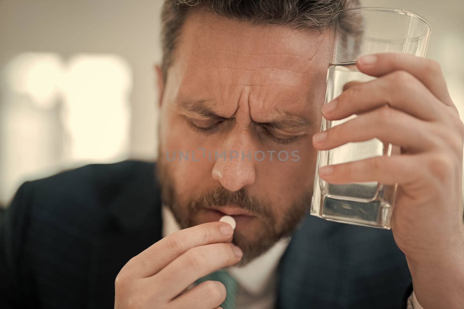 Tired man feel pain holding glasses rubbing dry irritated eyes fatigued from computer work, stressed man suffer from headache. Man taking a Medicine pill from headache migraine