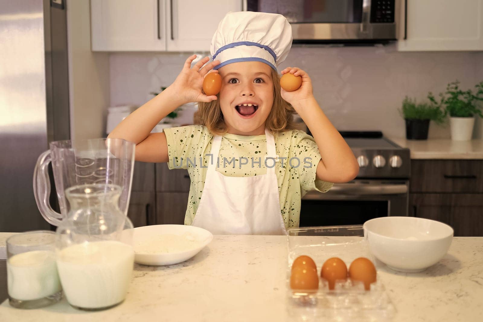 Child chef cook. Funny child stand at kitchen table have fun baking, doing bakery preparing food at home kithen. Healthy food. Little chef preparing healthy meal. by RedFoxStudio