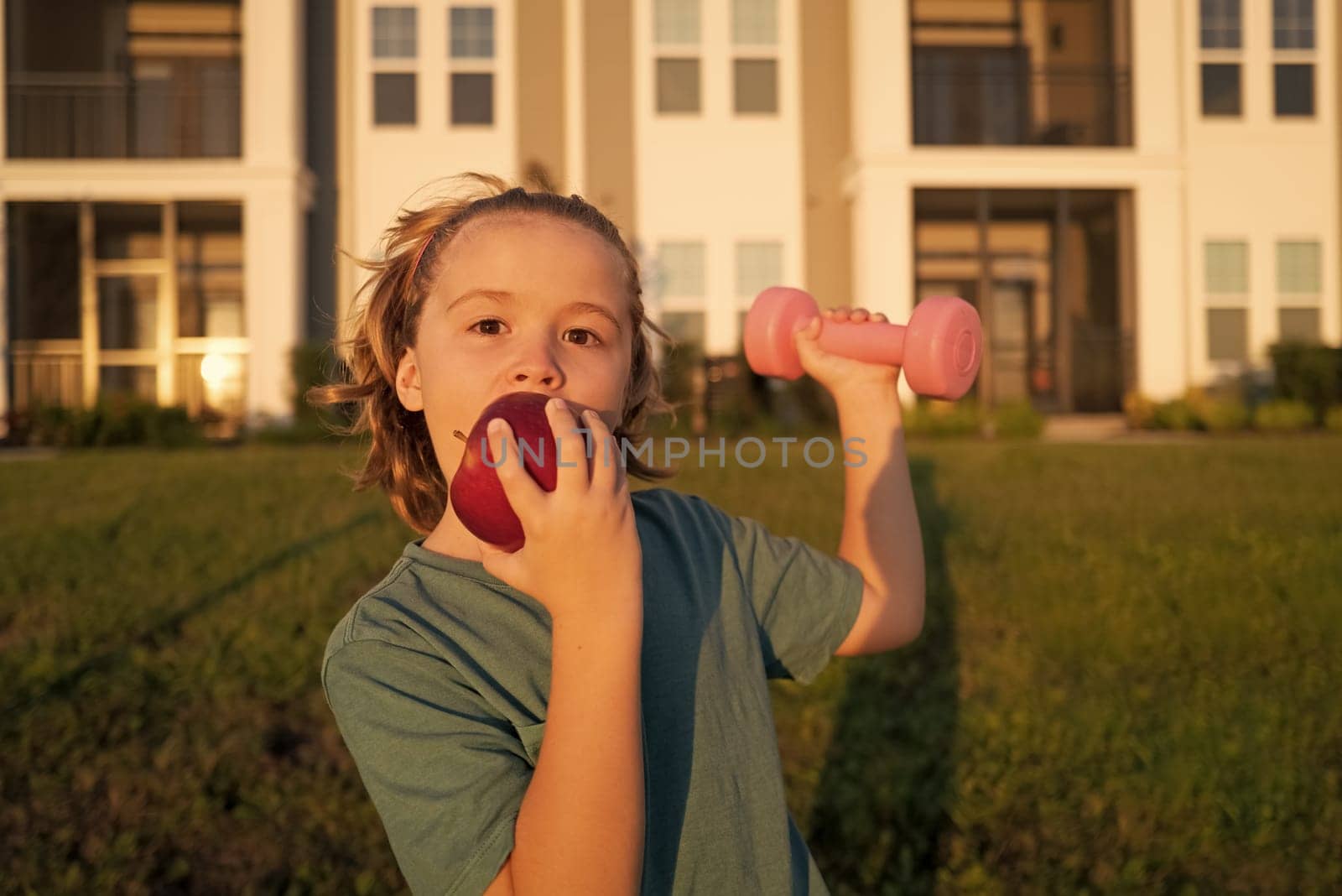 Kids sport training outdoor. Sport activities at leisure with children. Sporty kid boy holding dumbbells