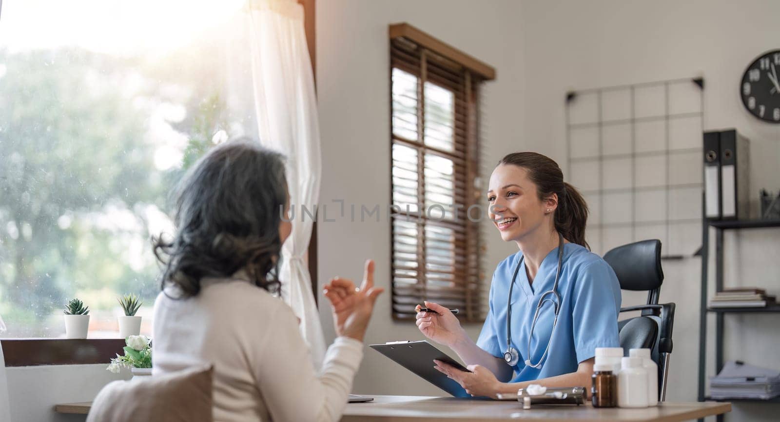 Positive minded nurse taking care of elderly woman at home.