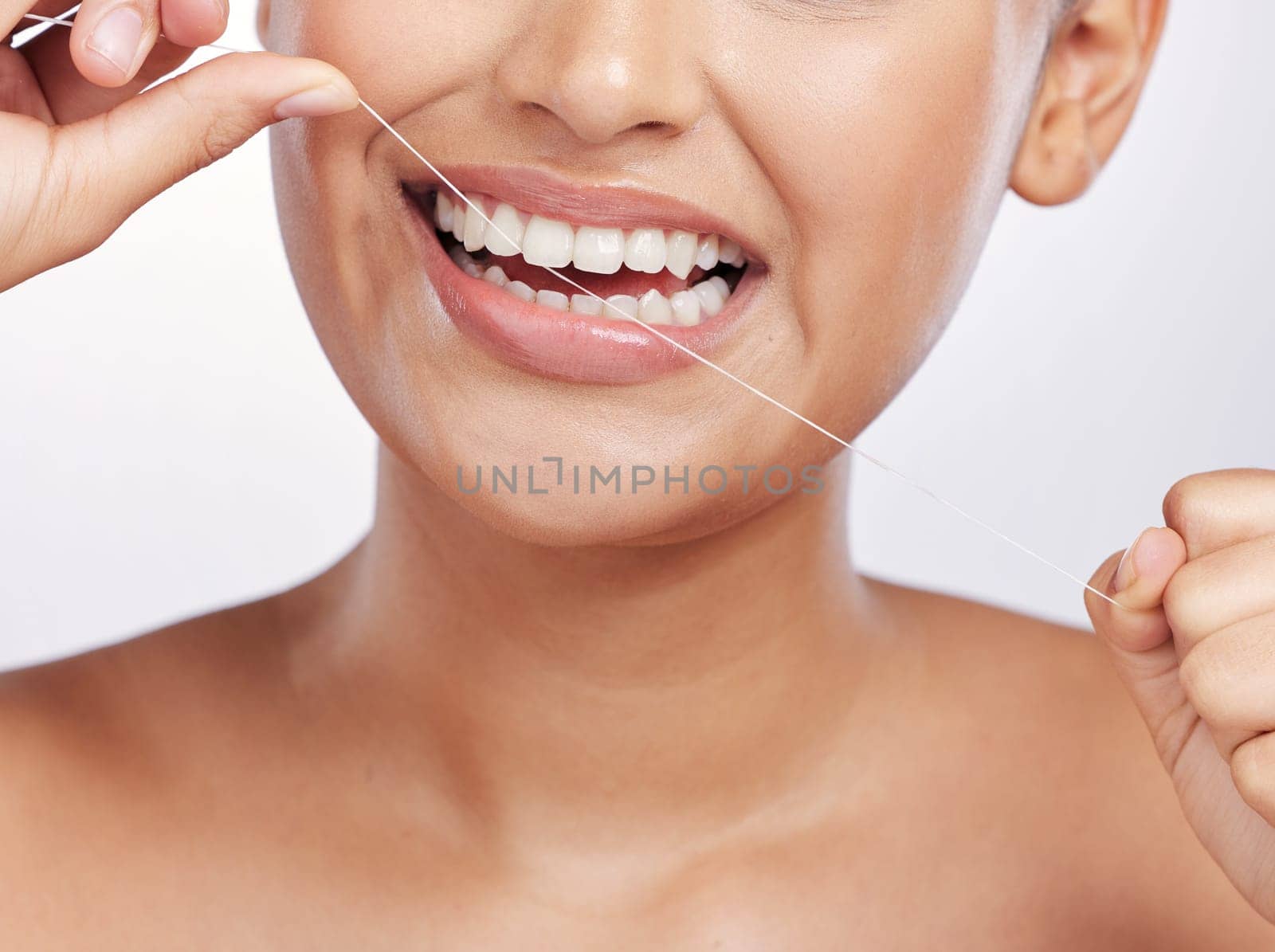 Mouth, face and woman floss teeth for dental health, care or gingivitis on studio background. Closeup of female model, oral thread and cleaning string for fresh breath, tooth hygiene or healthy habit.