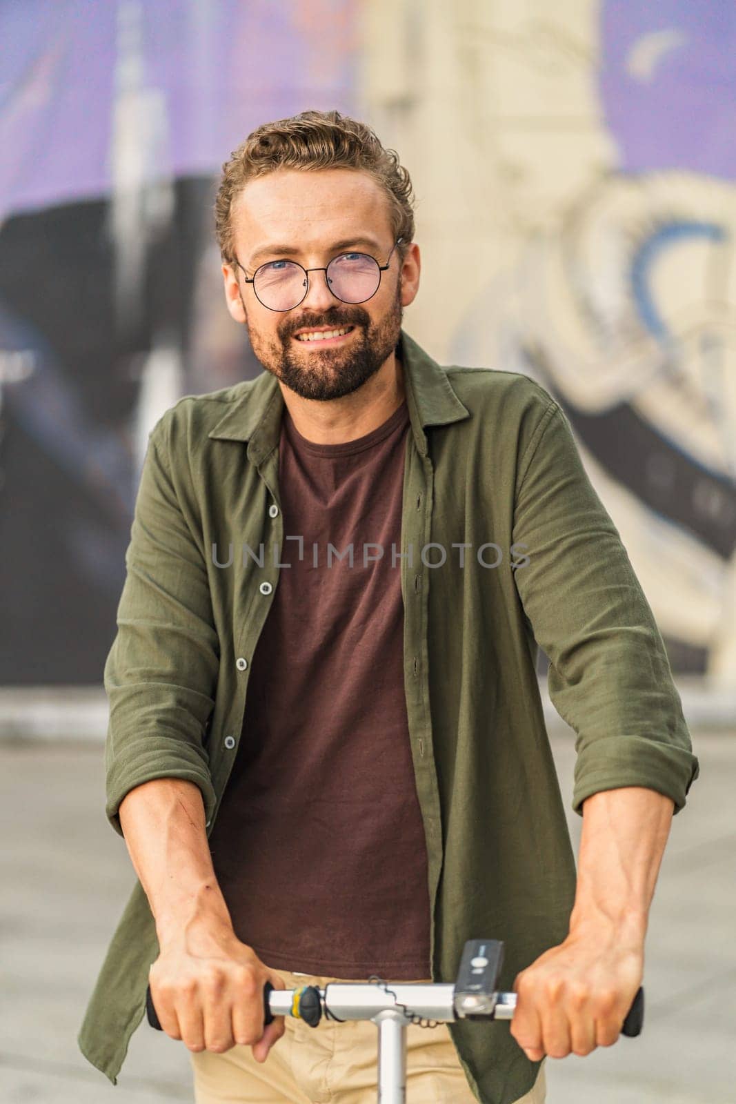 Man photographed outdoors, basking in natural sunlight. With confident and stylish appearance, he exudes relaxed and charismatic vibe. outdoor setting adds touch of authenticity and freshness to image. High quality photo