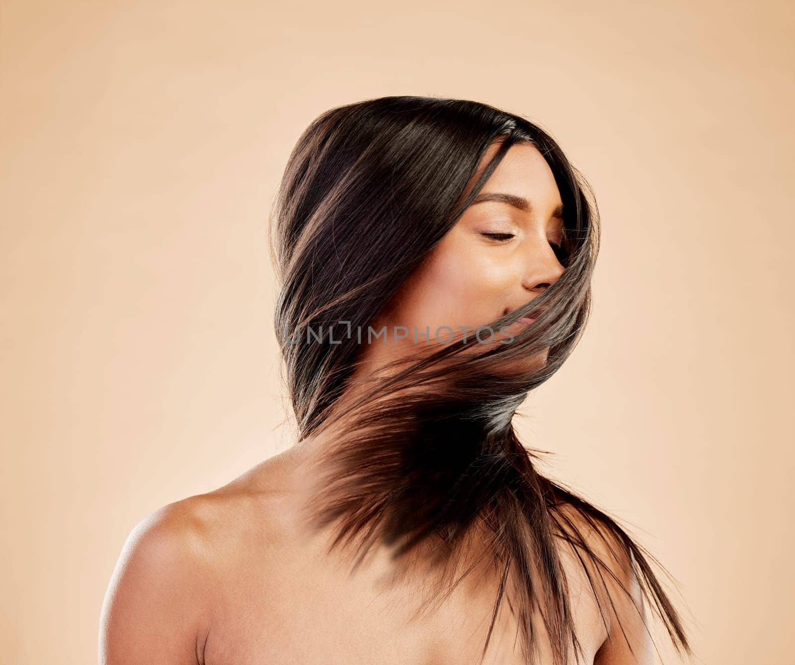 Woman, shake hair and beauty with growth, texture and shine with natural cosmetics on studio background. Indian female model, satisfied with salon treatment and Brazilian, hairstyle and haircare.