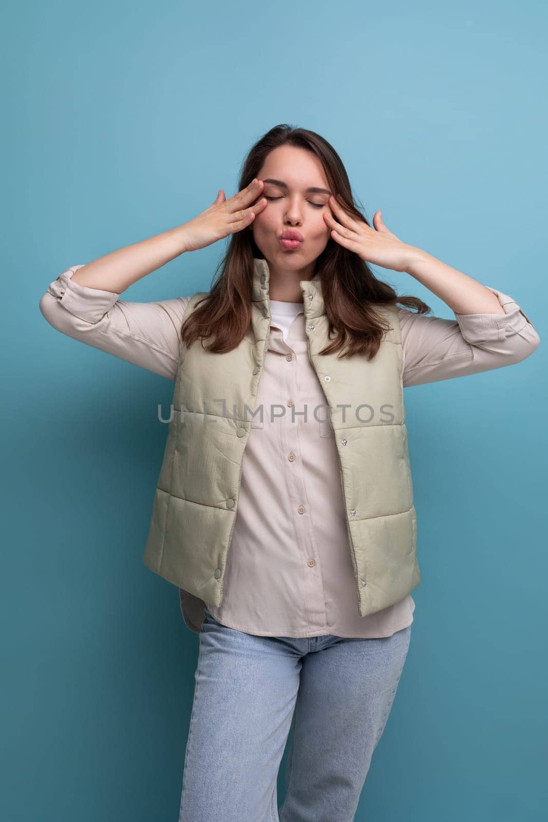 funny brunette young woman making face on studio background.