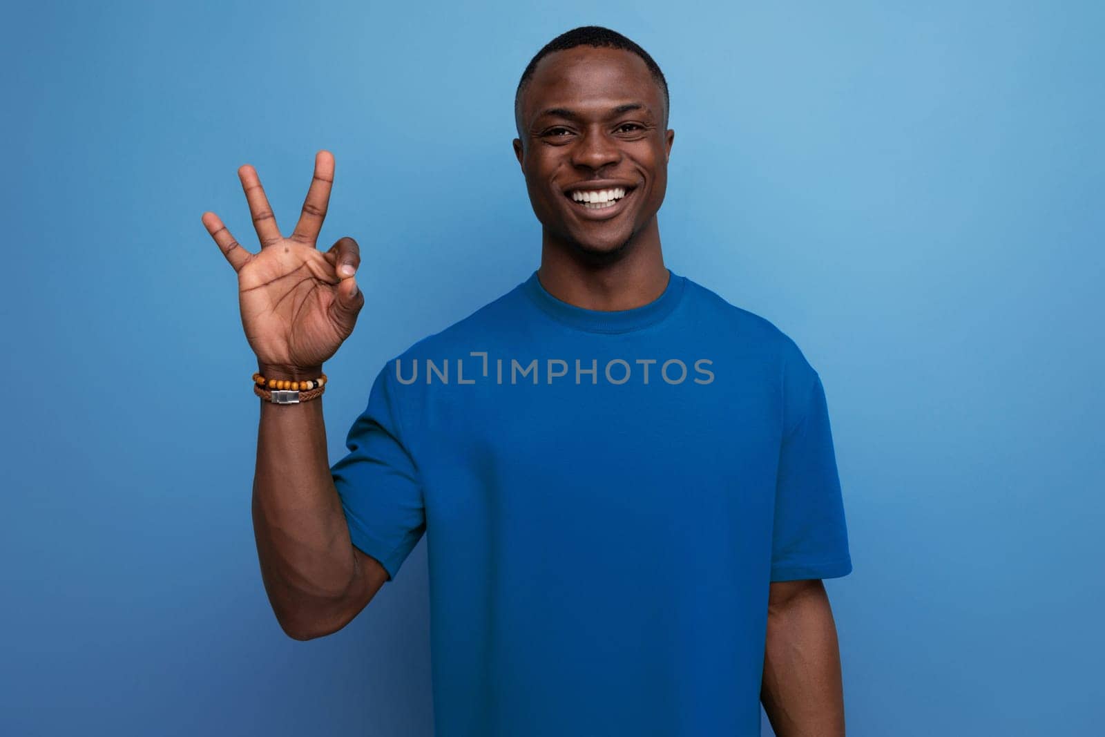 young friendly american man in a t-shirt on a blue background with copy space. people lifesal concept.