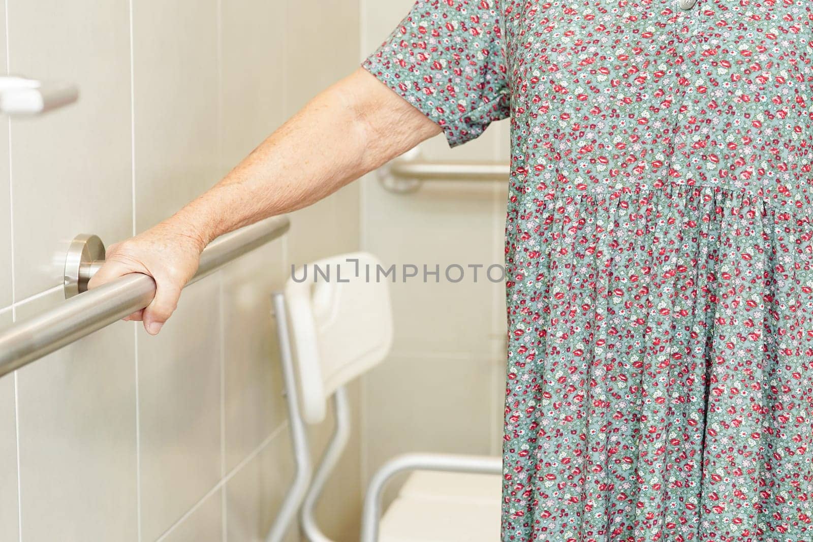 Asian elderly old woman patient use toilet support rail in bathroom, handrail safety grab bar, security in nursing hospital.