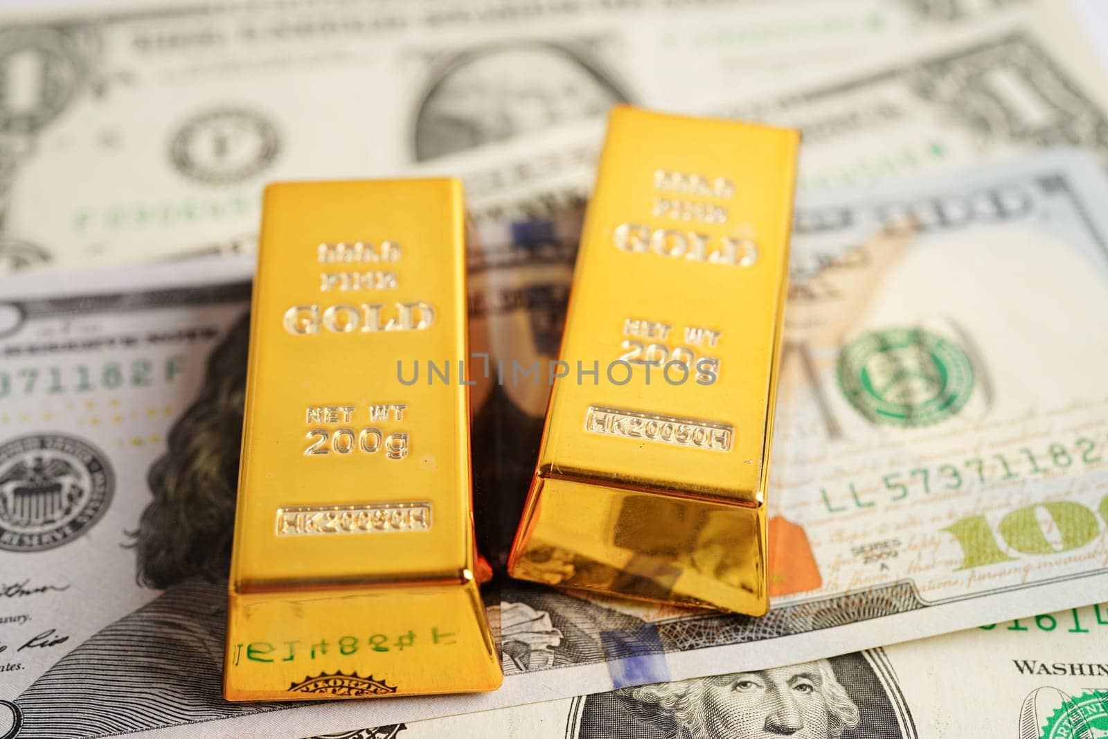 Gold bars on US dollar banknote money, finance trading investment business currency concept. 