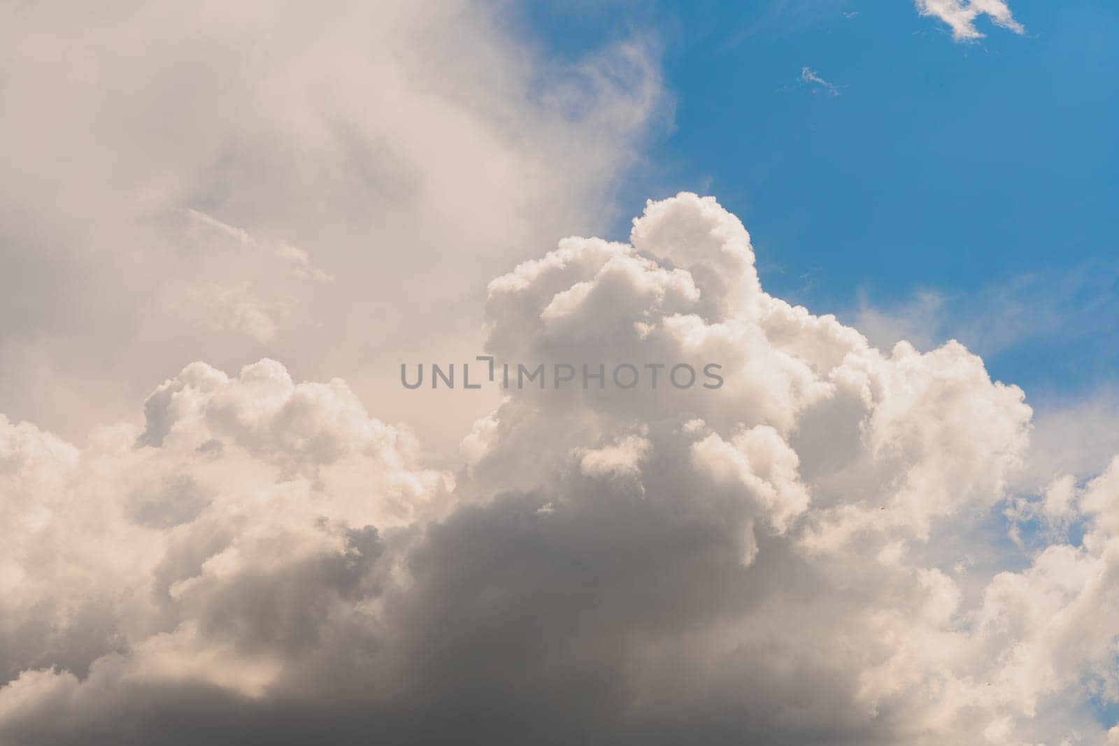 Sky with huge white clouds in spring on a sunny day. Huge white clouds on the sunny day background