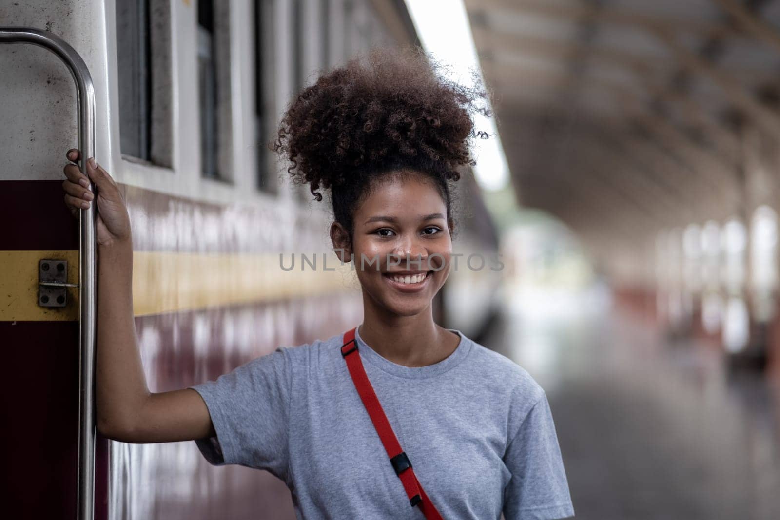 Traveler african asian american woman getting in a train to hop on train, Young woman female standing on train door by wuttichaicci