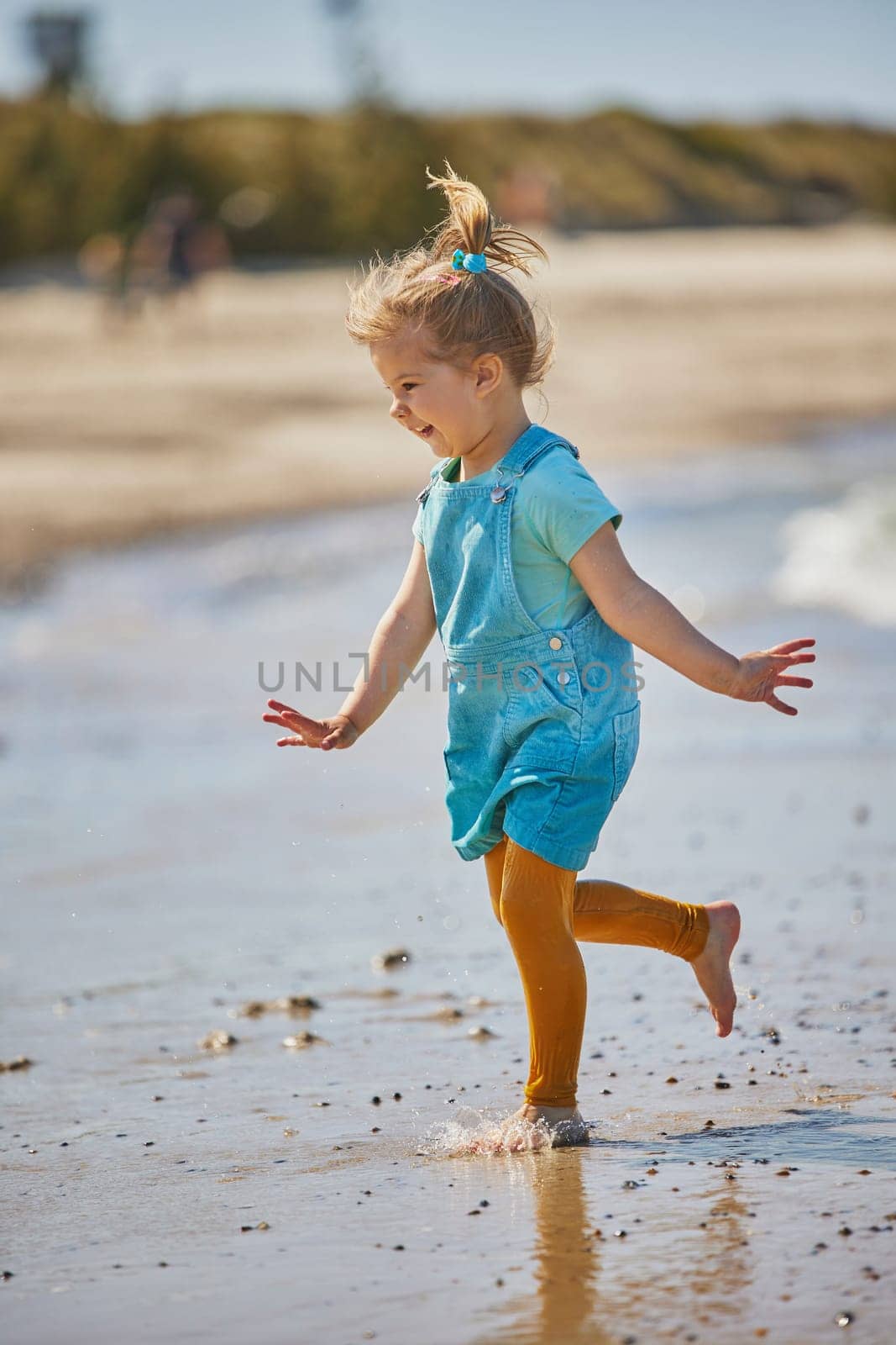 Charming child playing on the beach in Denmark.