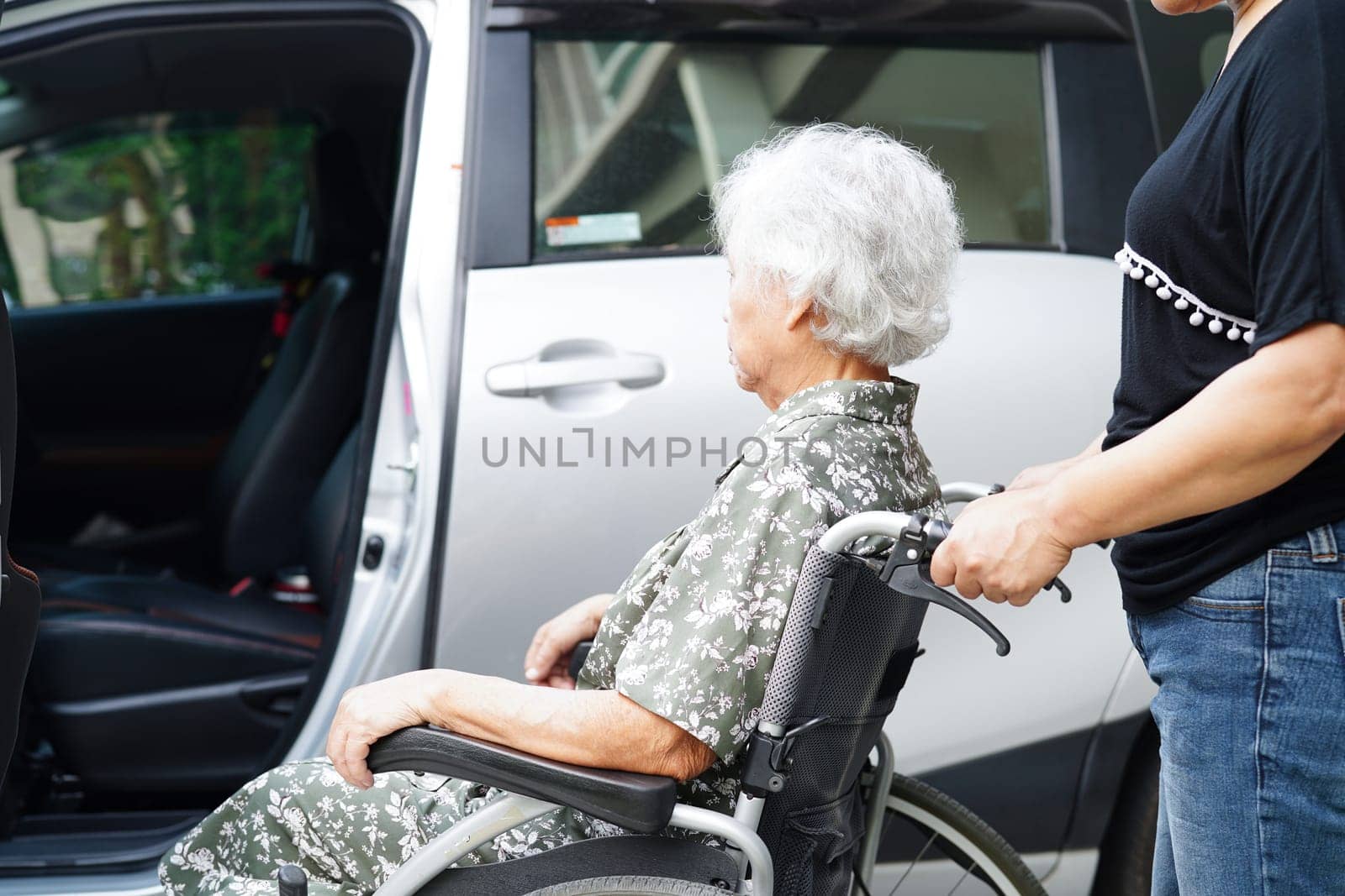 Caregiver help Asian elderly woman disability patient get in her car, medical concept.