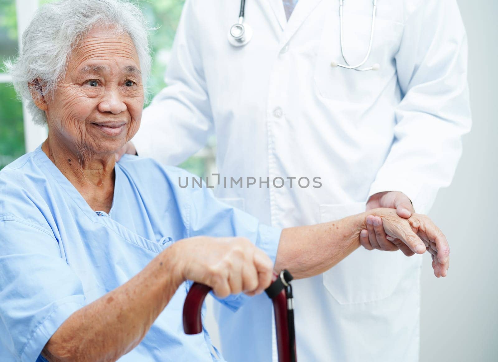 Doctor holding hands Asian elderly woman patient, help and care in hospital.