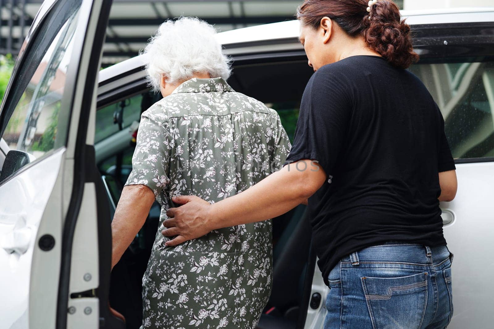 Caregiver help Asian elderly woman disability patient get in her car, medical concept. by sweettomato