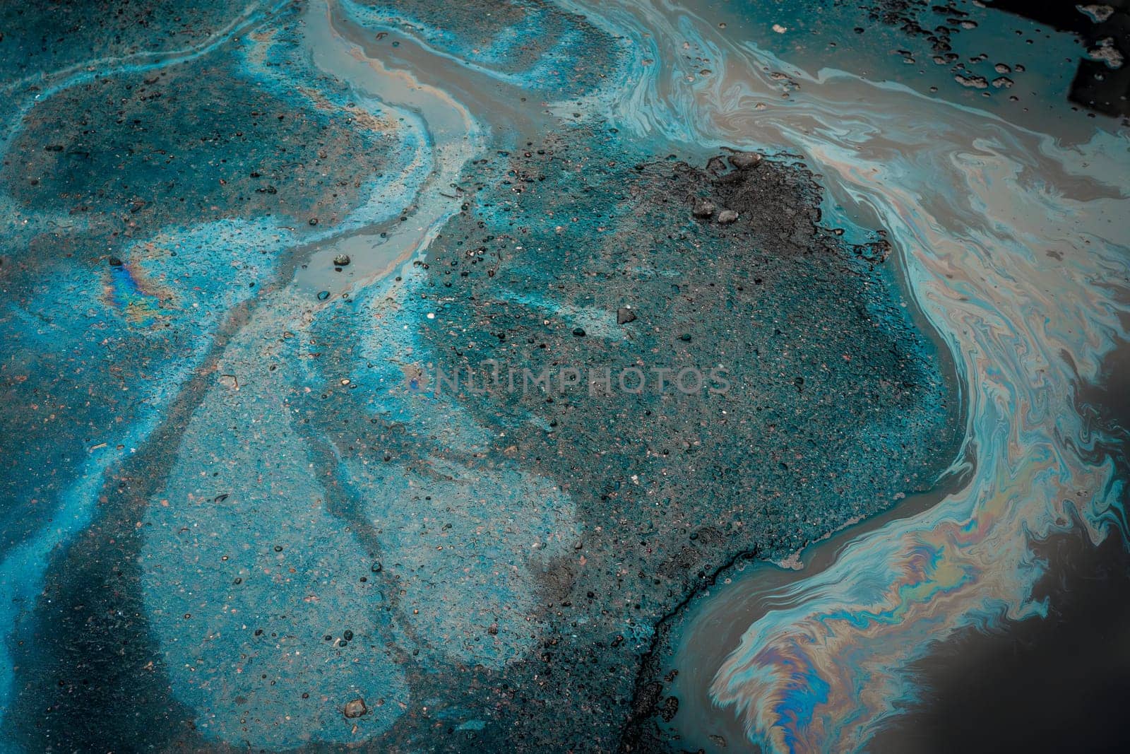 Gasoline on wet pavement leaves a big stain. Environmental pollution concept